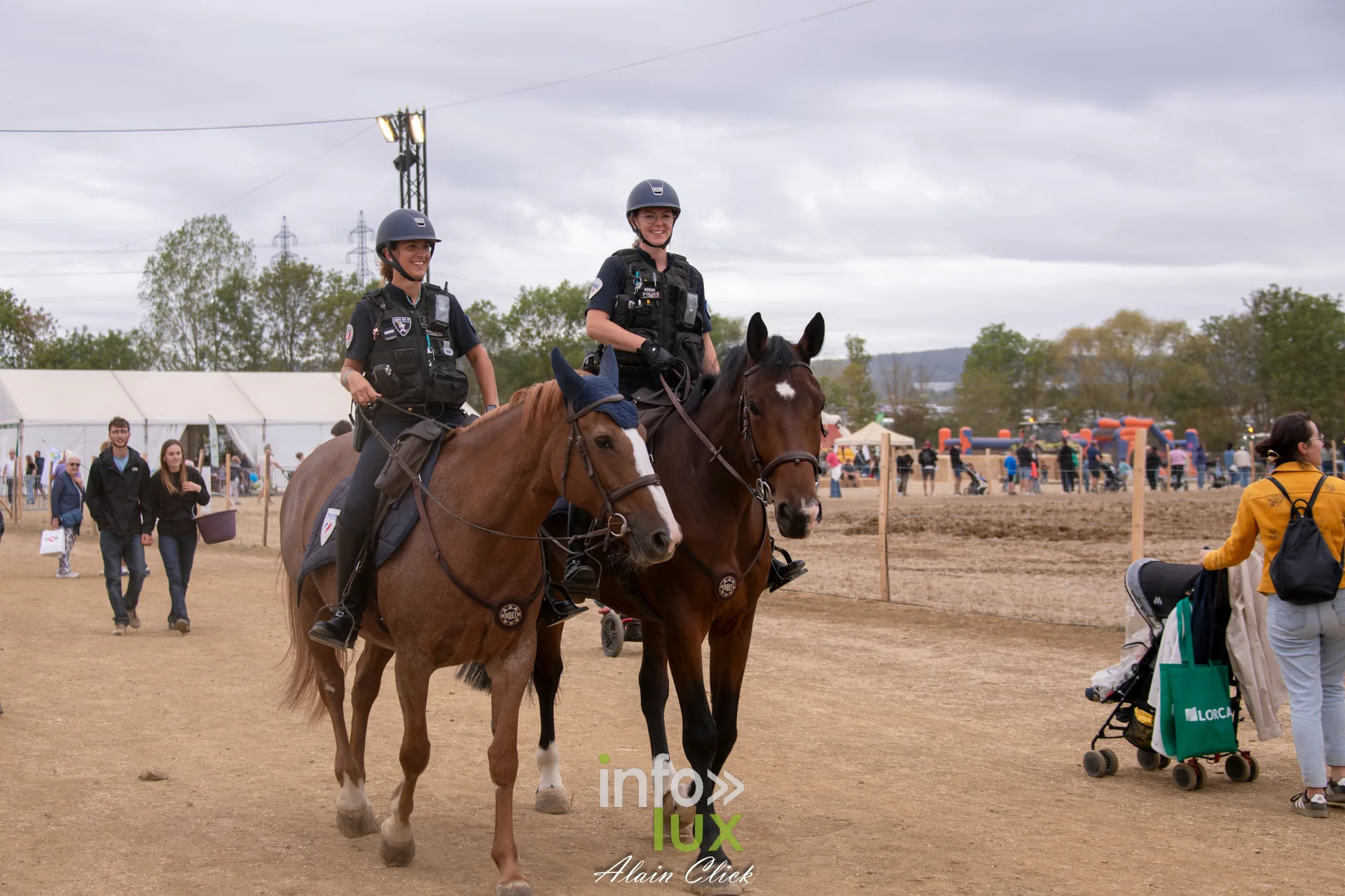 Deux policieres a cheval traversant les allees des Terres de Jim