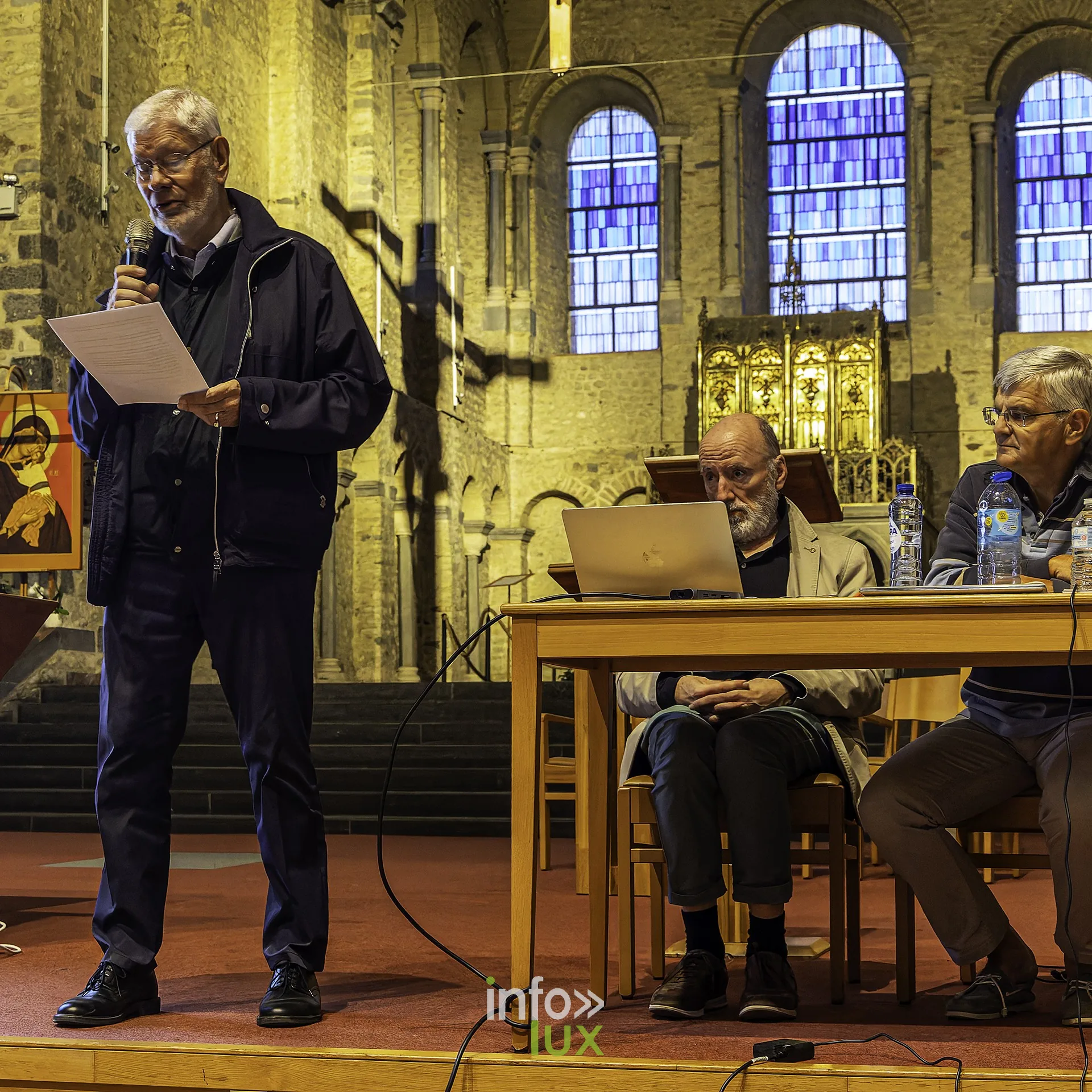 Emmanuel Collet, historien, ouvre la soirée à la tribune, texte en main, devant le public