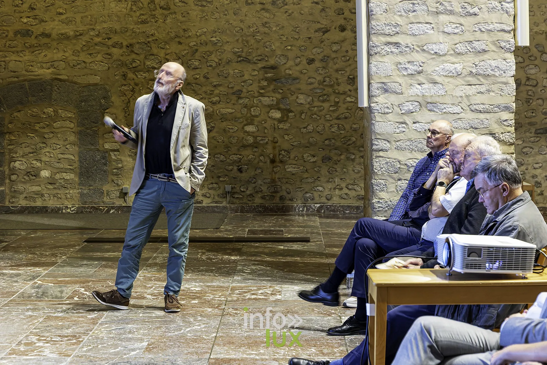 Philippe Draps, président du Comité du Tour, marche devant le public en parlant