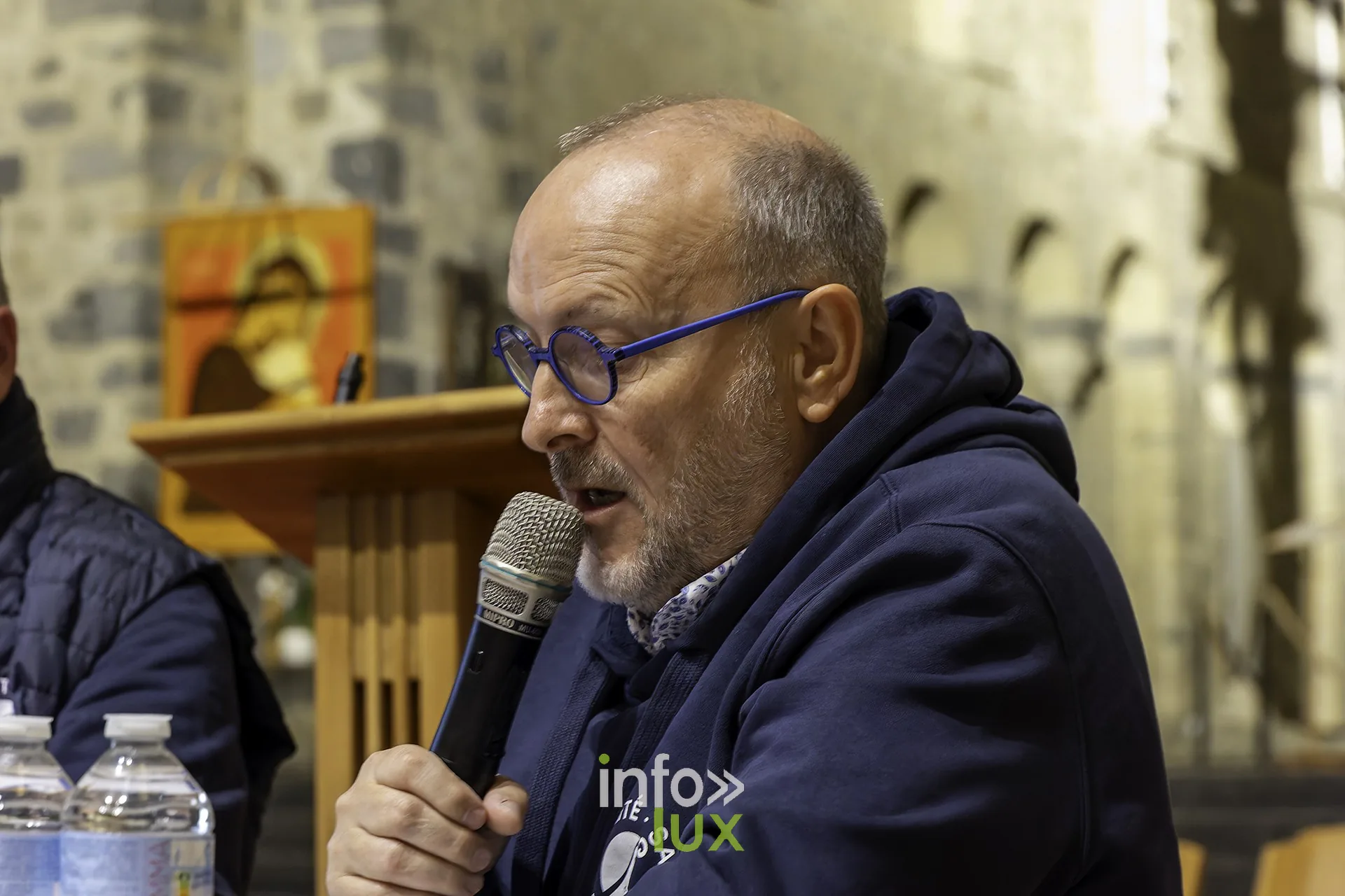 Eddy Vanhelmont, président du Royal Photo Club Entre Nous, au micro, assis à la table