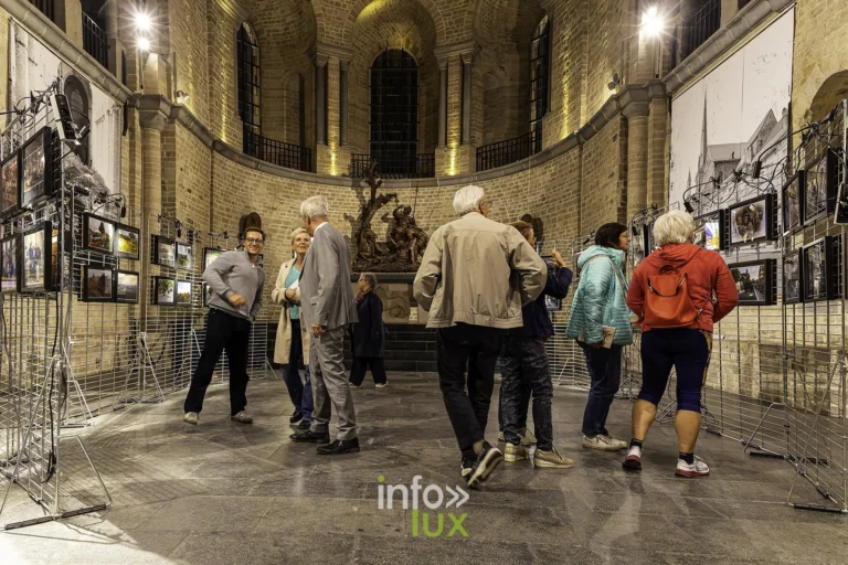Groupe de visiteurs devant les photos du Tour, dans le chœur de la collégiale