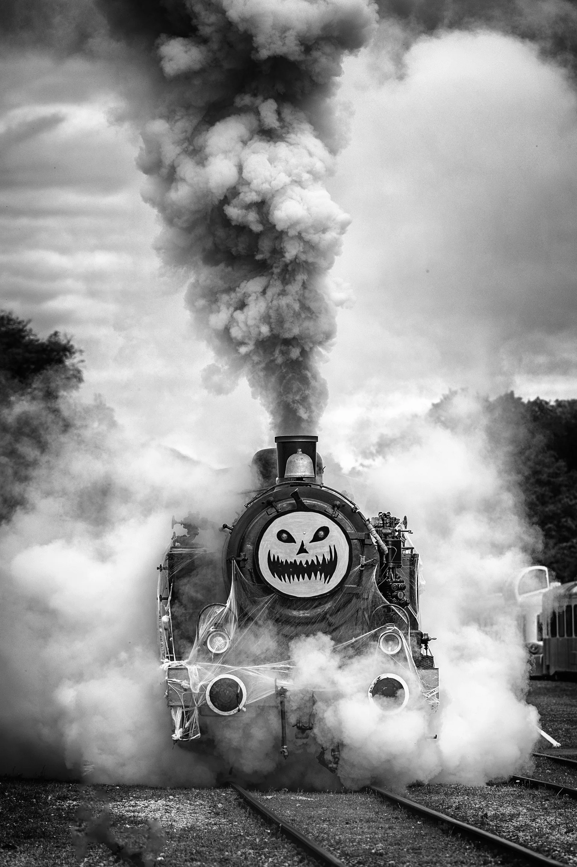 Locomotive à vapeur à tête de citrouille dans un nuage de fumée, photo noir et blanc du train d’Halloween du CFV3V