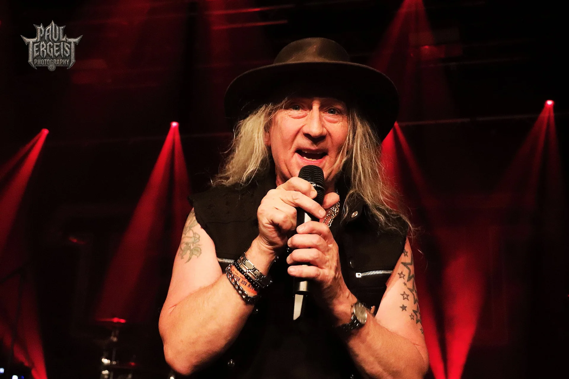 Chanteur de Treat avec un chapeau noir au micro au Golden Age Rock Festival