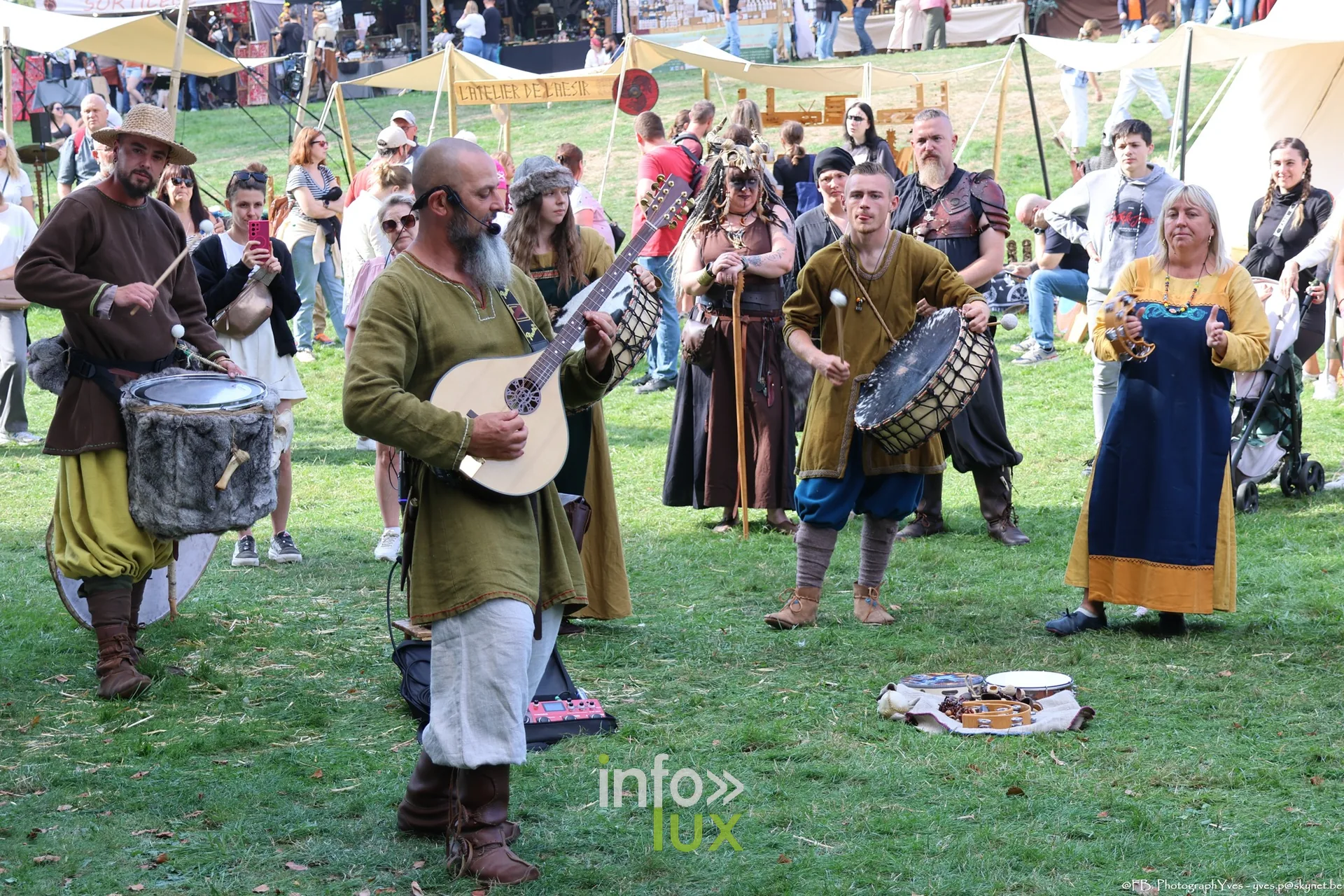 Musicien au luth et joueurs de tambour en costume viking devant le public à Ciney