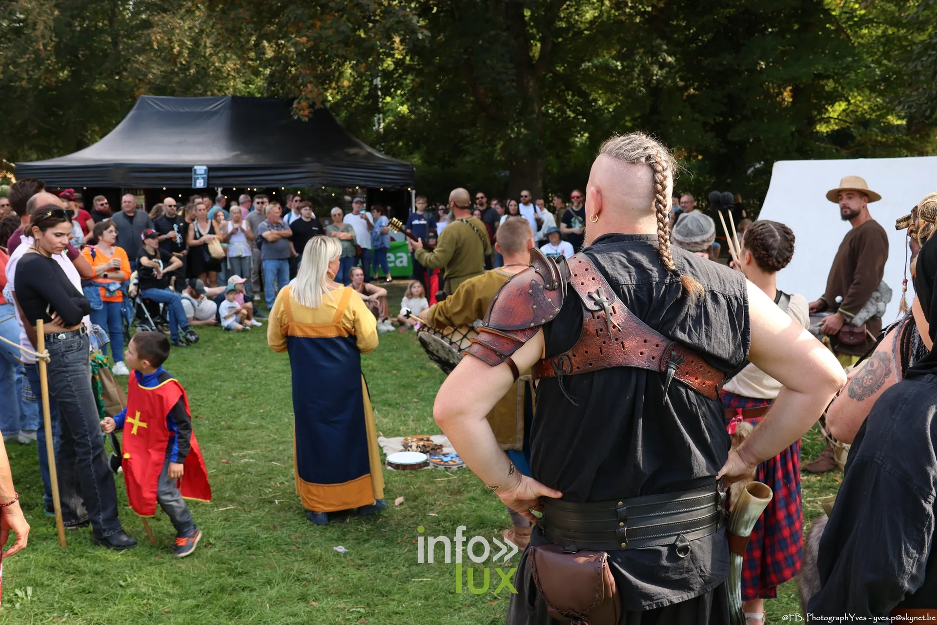Reconstituteurs et enfants au centre d’une animation, parc Saint-Roch à Ciney