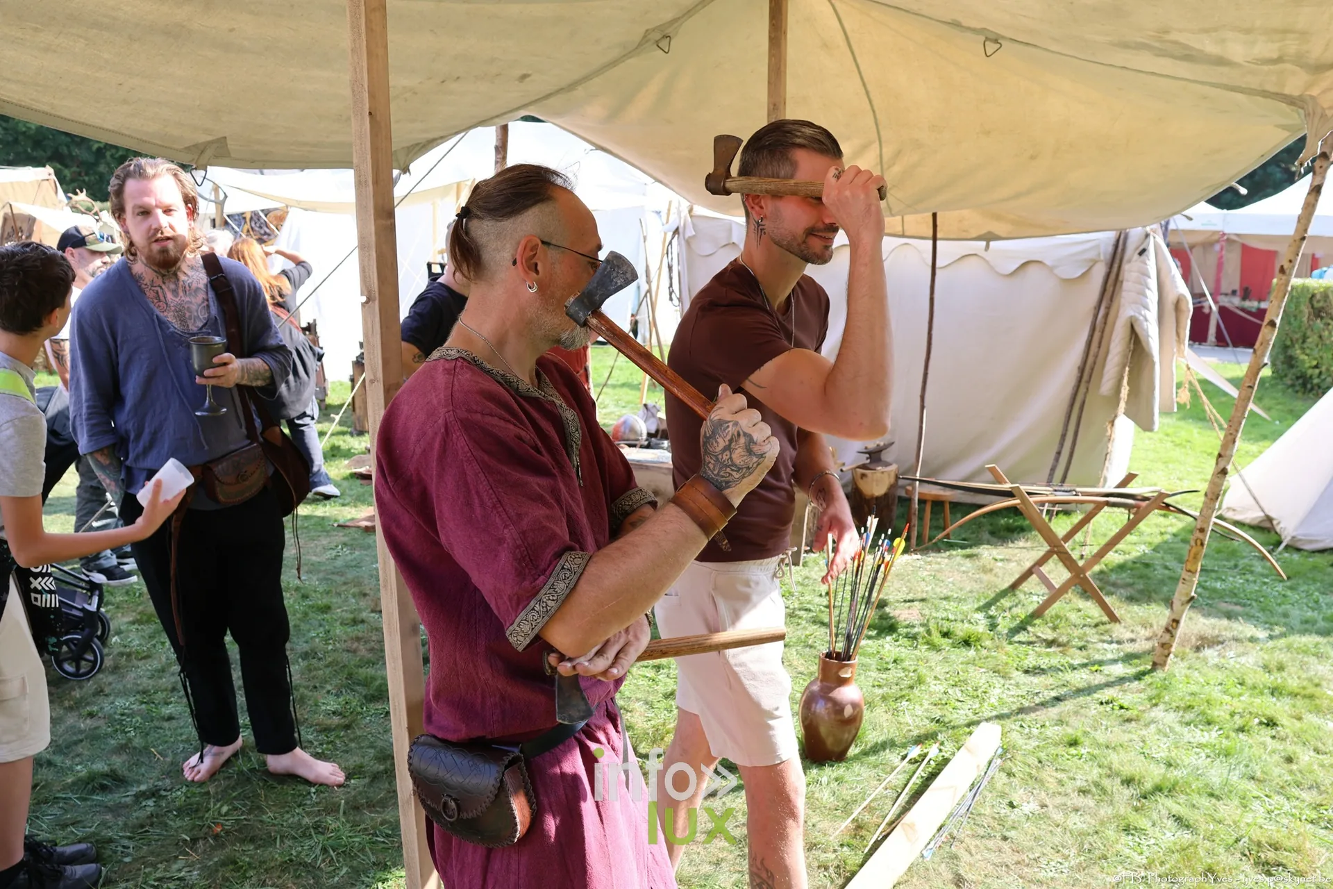 Une participante en tenue viking, bouclier peint à ses côtés, devant un stand des Valhalla Days 2026 au parc Saint-Roch à Ciney