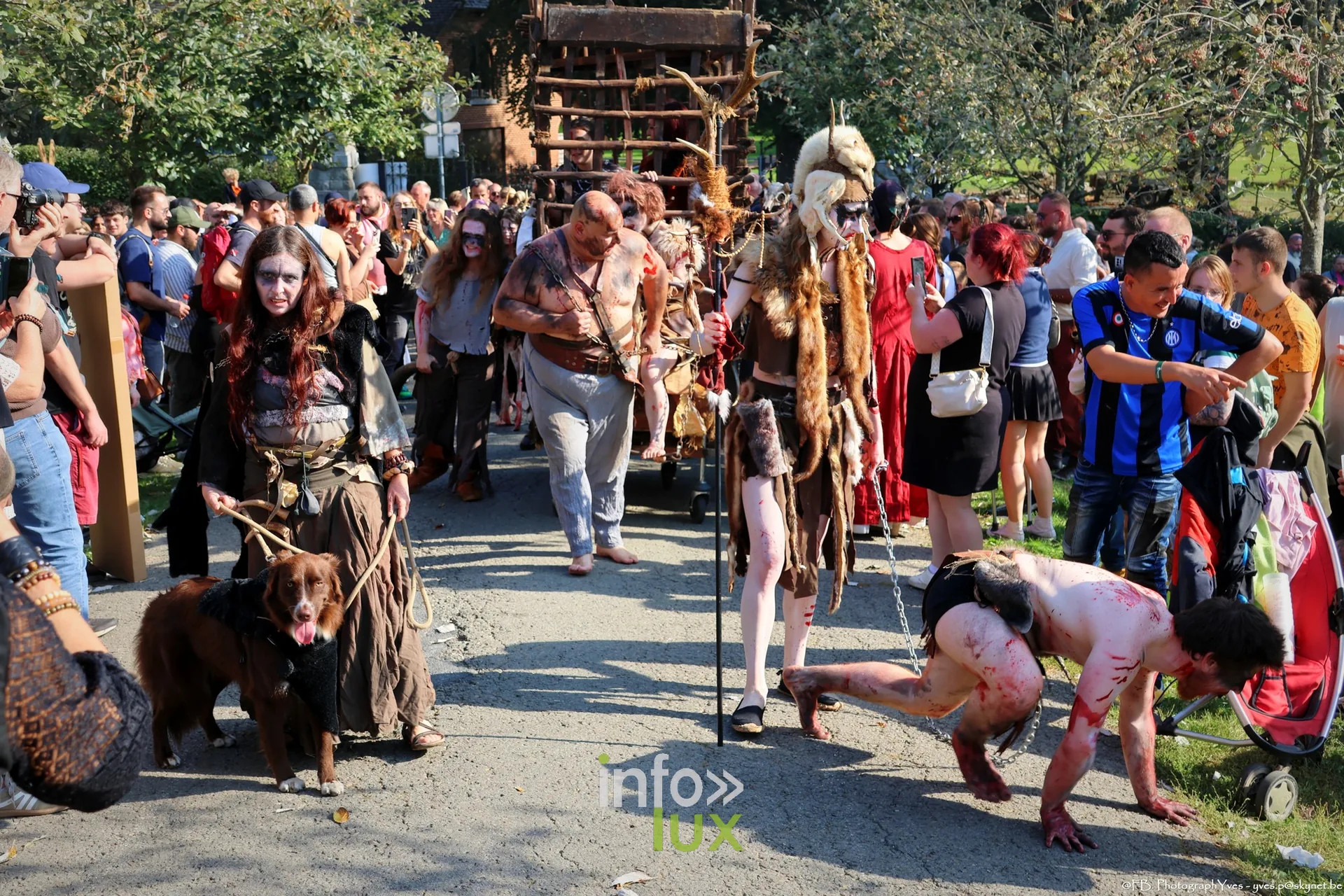 Figurants grimés en captifs dans les allées, à côté d’une cage en bois, Valhalla Days 2026