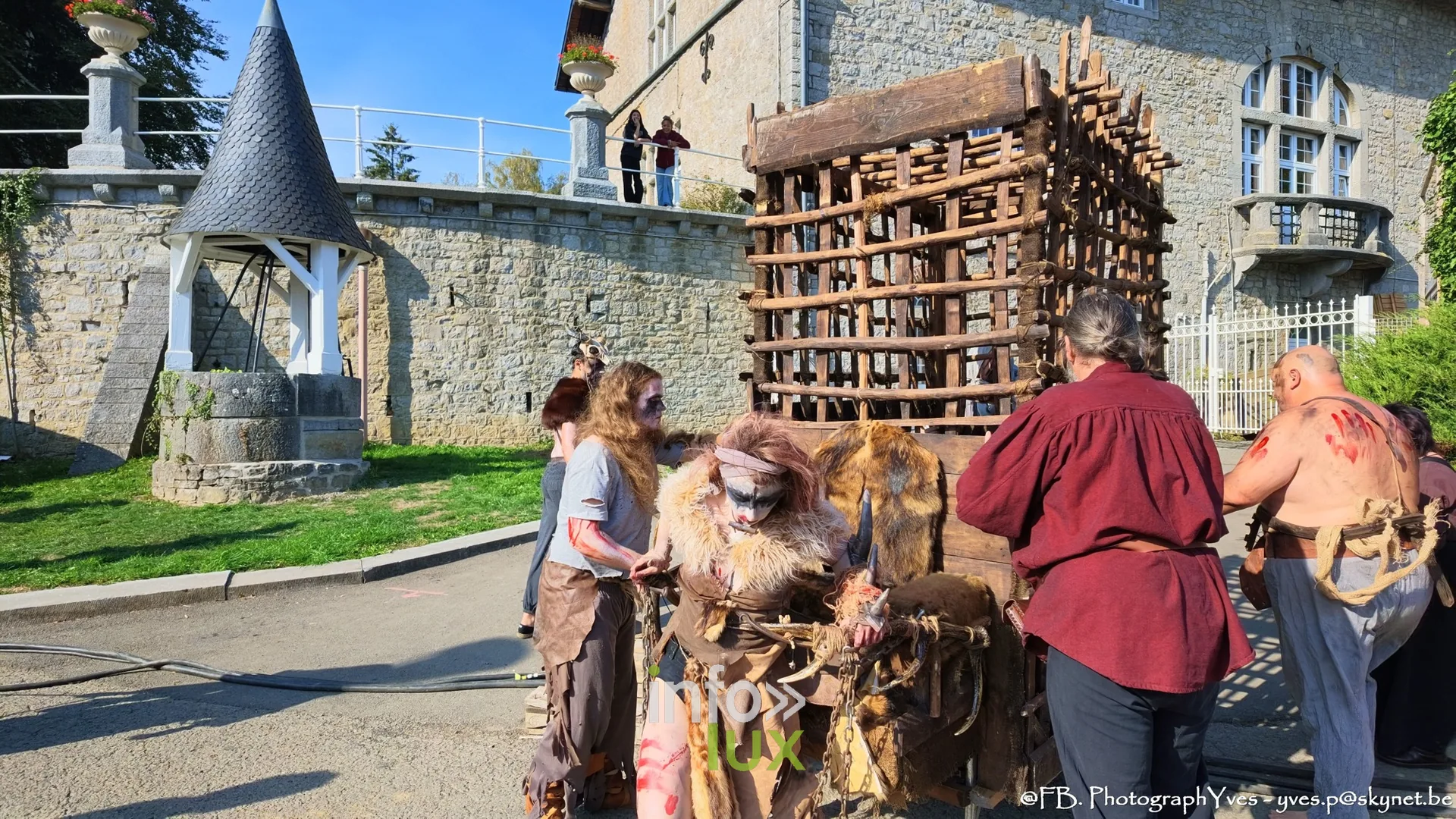 Cage en bois et figurants grimés près du mur d’enceinte du parc Saint-Roch