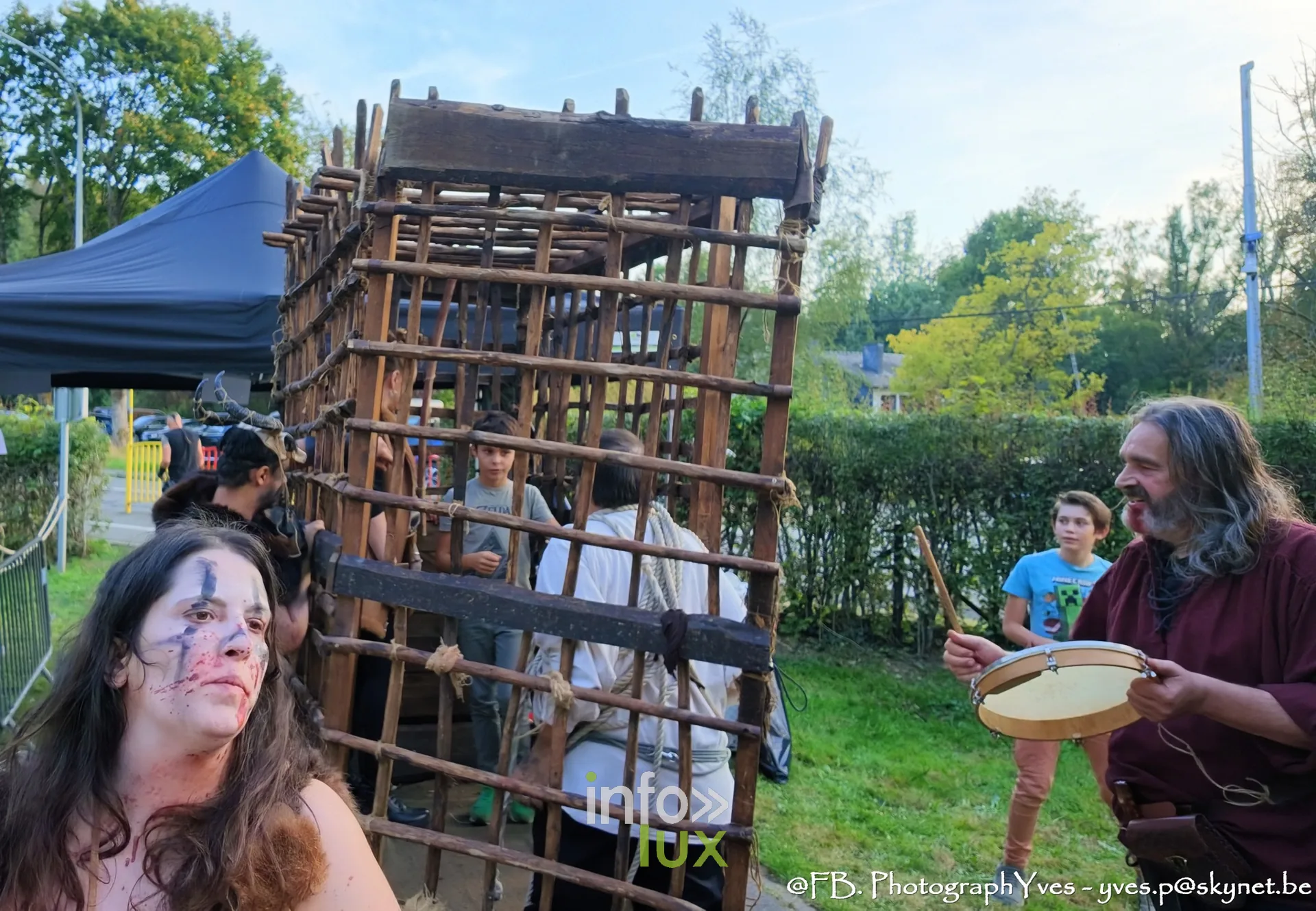 Figurante grimée devant la cage en bois, reconstituteur au tambourin, Valhalla Days 2026