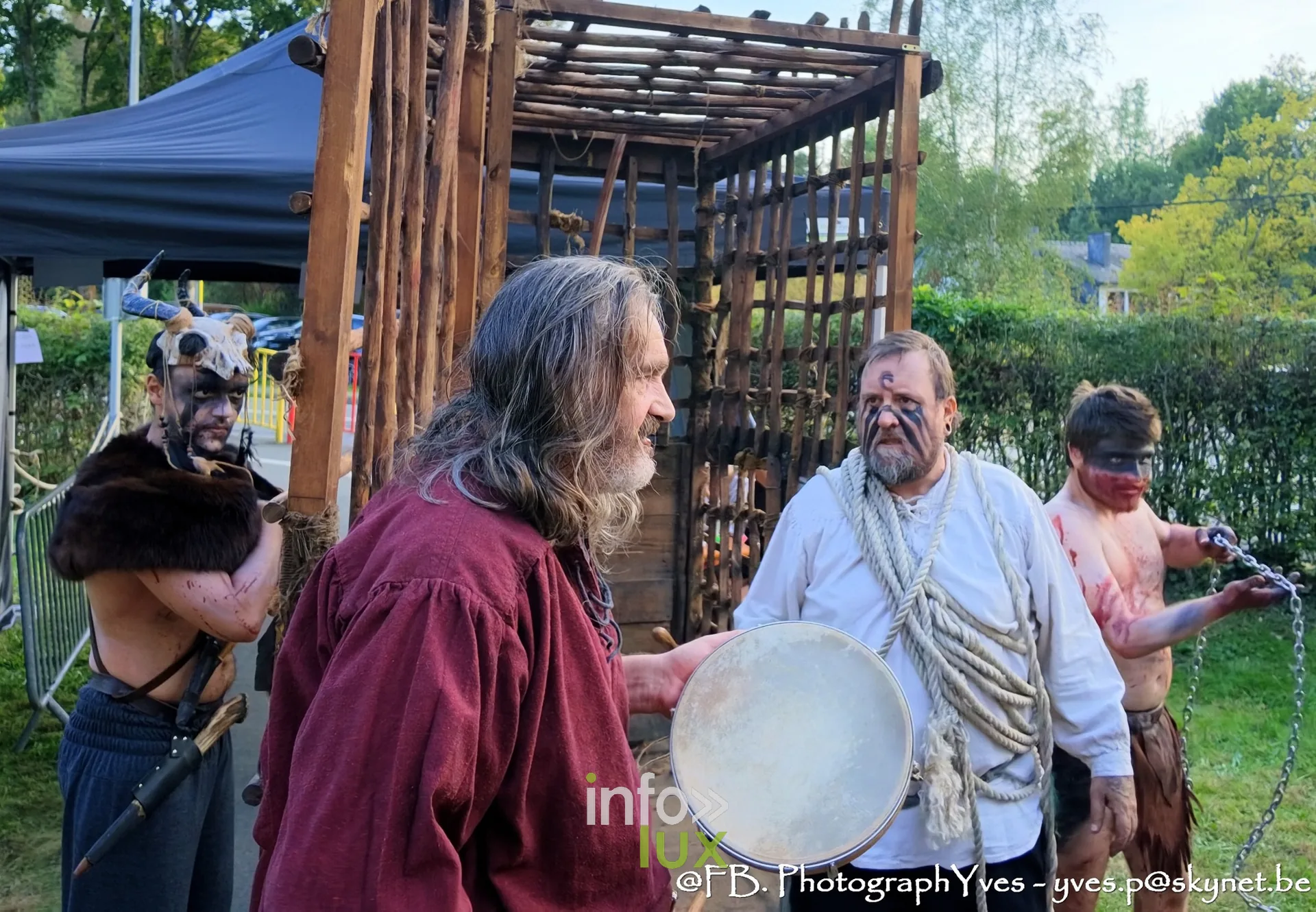 Reconstituteurs costumés devant la cage en bois, l’un au tambourin, Valhalla Days 2026