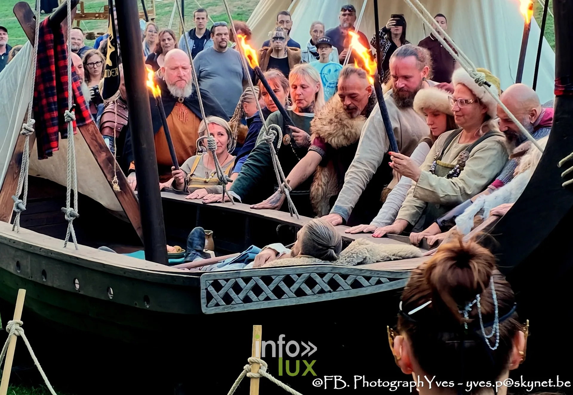 Reconstituteurs et torches autour du défunt allongé dans le bateau viking, Ciney
