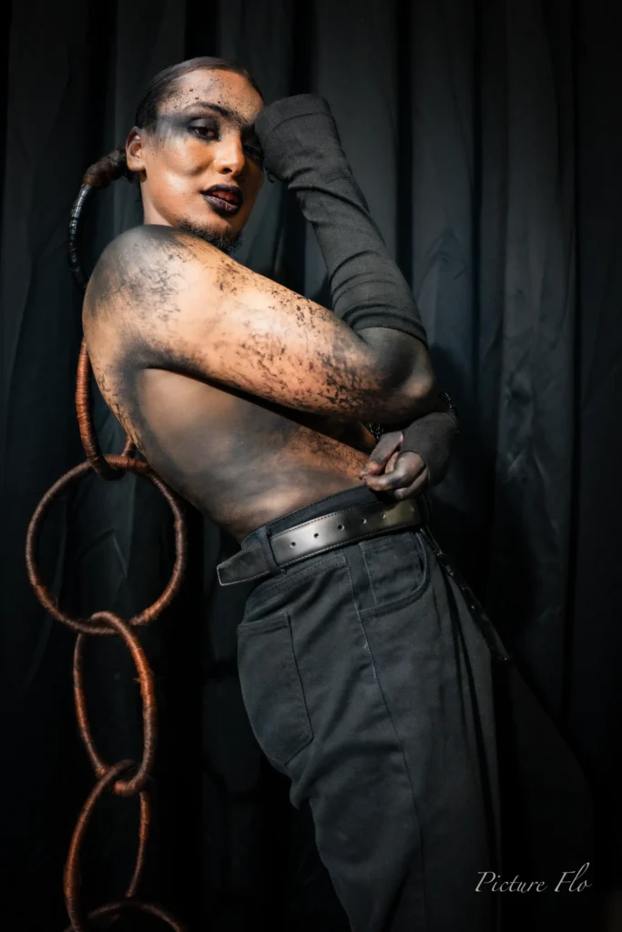 Youness en studio, bras replié sur le visage, chaîne d’anneaux en cheveux, Lux Fashion Week 2026, Arlon