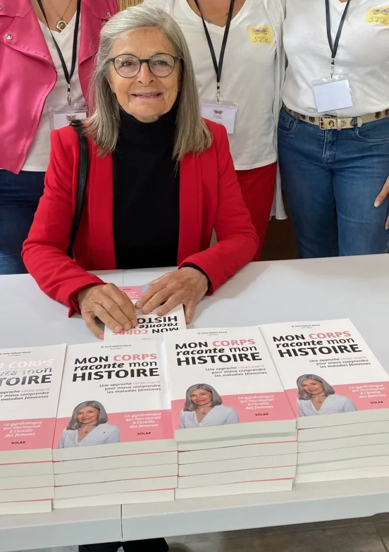 Le Dr Anne Gabard-Allard derrière une pile de son livre Mon corps raconte mon histoire