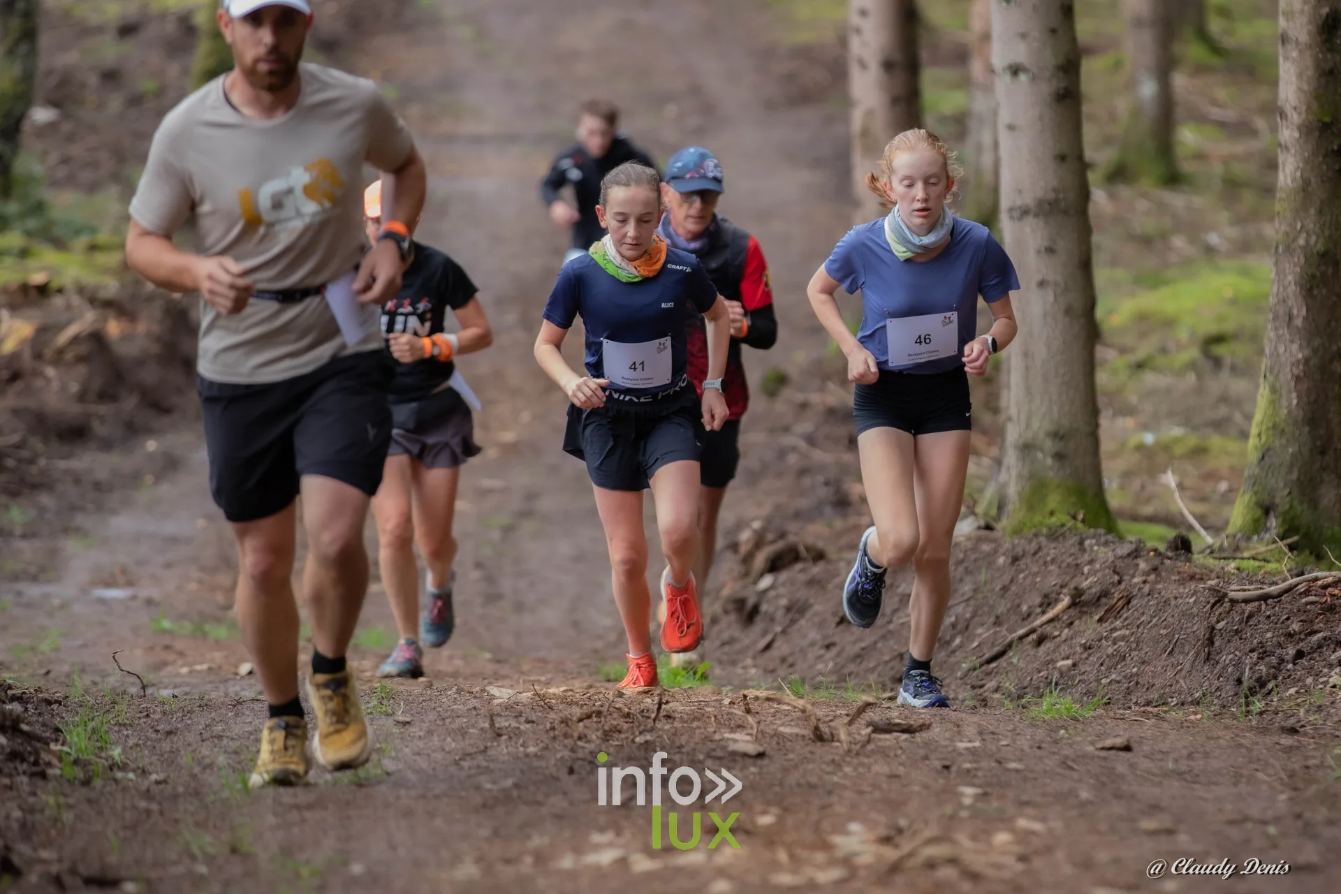 Backyard de Chôdes 2026 à Malmedy : un coureur et de jeunes coureuses dans la forêt d’épicéas (photo Claudy Denis)