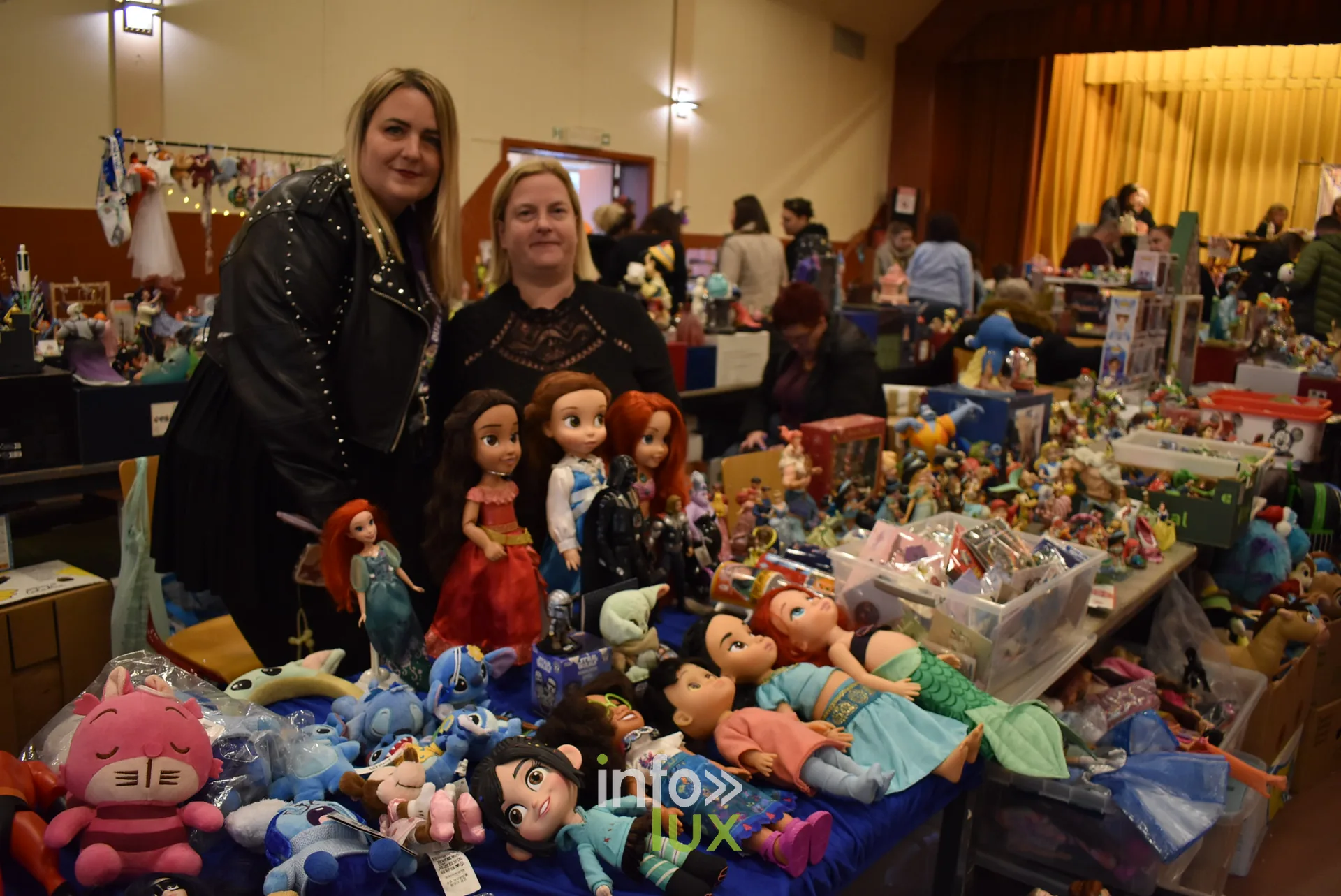 Meeting Disney et pop culture « Entre Ombres et Lumière » de Be Maf, Maison de Tous, Braine-l’Alleud, 31 octobre 2026 : des exposantes derrière un stand de peluches (photo info-lux.com)