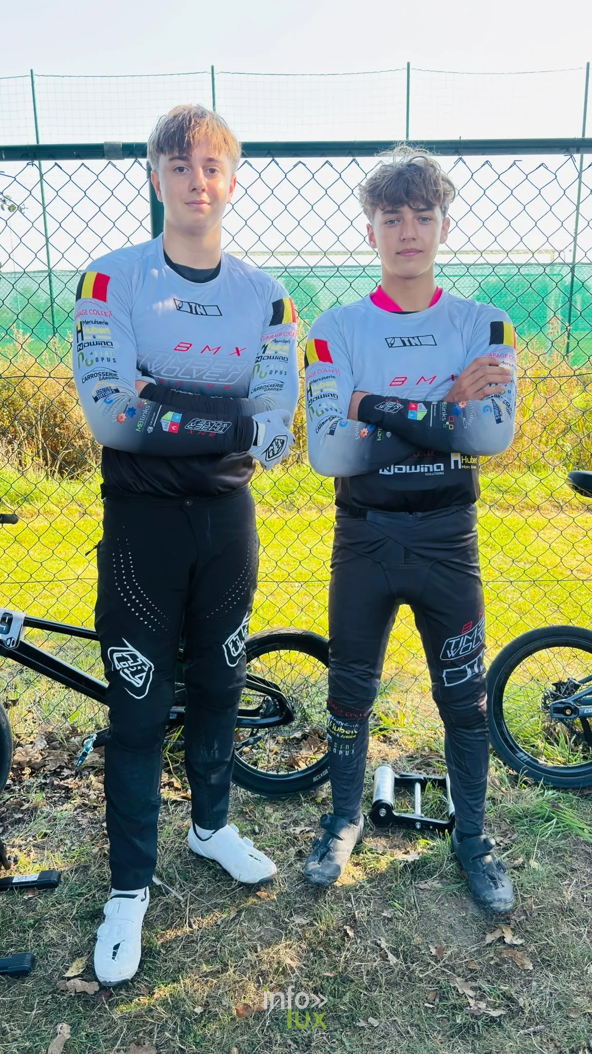 Deux jeunes pilotes du BMX Timberwolves Racing en maillot de club, à côté de leurs vélos à Ostende