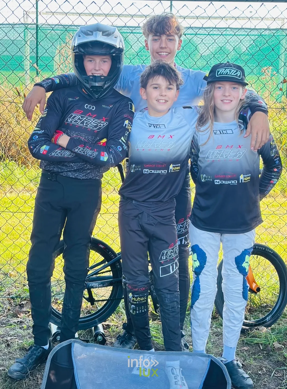 Quatre jeunes pilotes du BMX Timberwolves Racing, dont un casqué, posent avec leurs vélos à Ostende