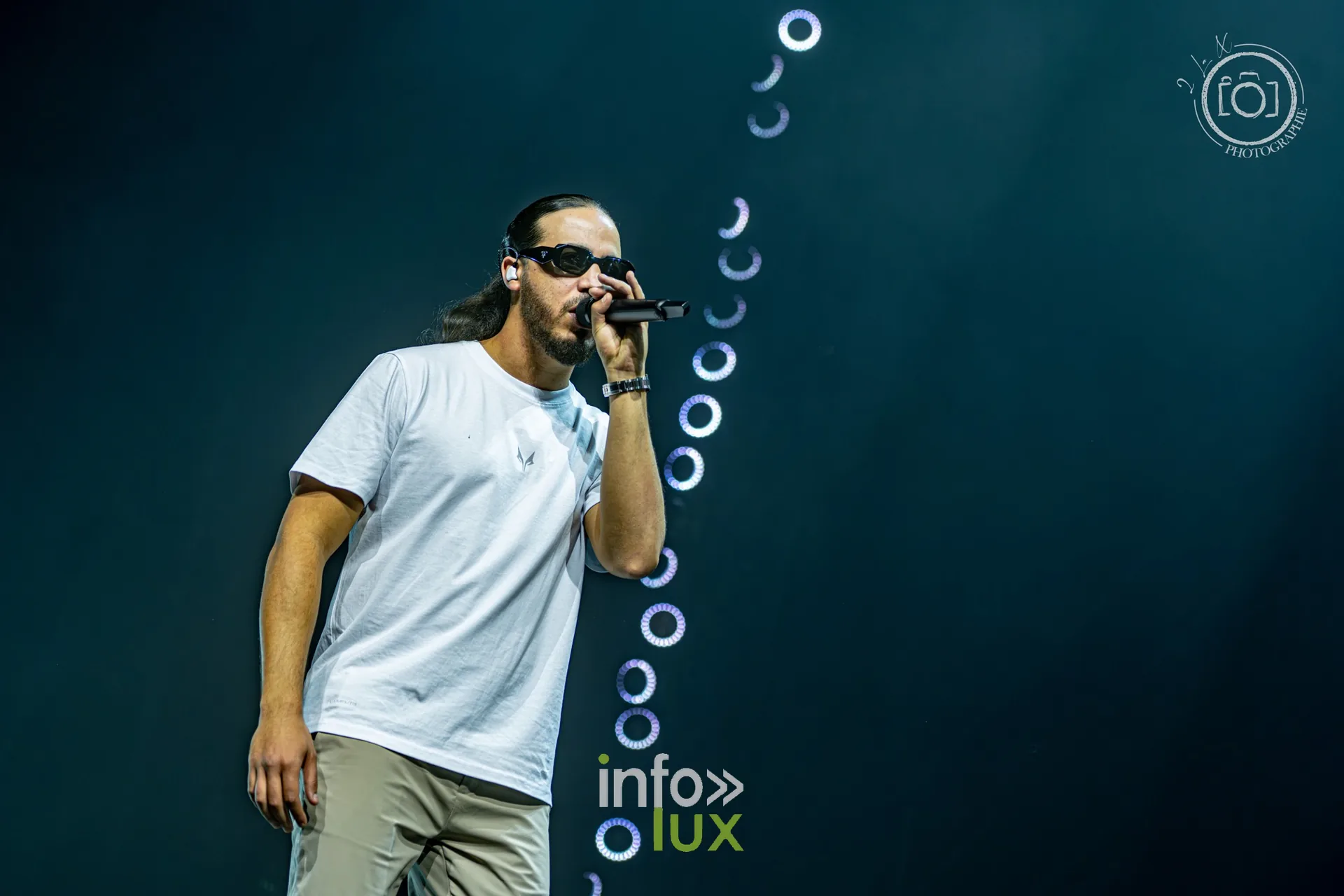 L’un des deux rappeurs du duo Djadja & Dinaz au micro devant un décor de cercles lumineux, concert de Djadja & Dinaz au Galaxie d’Amnéville, 26 septembre 2026