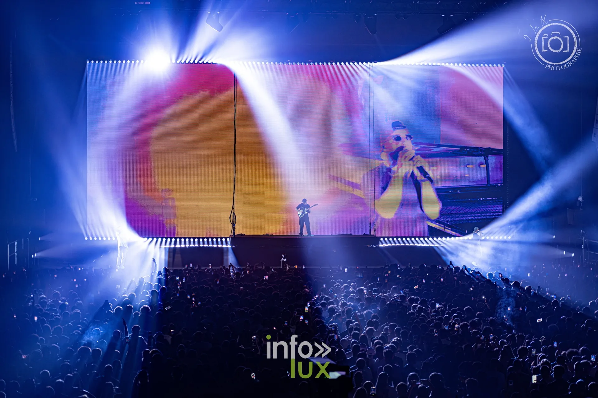 Faisceaux bleus et un rappeur projeté sur l’écran, concert de Djadja & Dinaz au Galaxie d’Amnéville, 26 septembre 2026