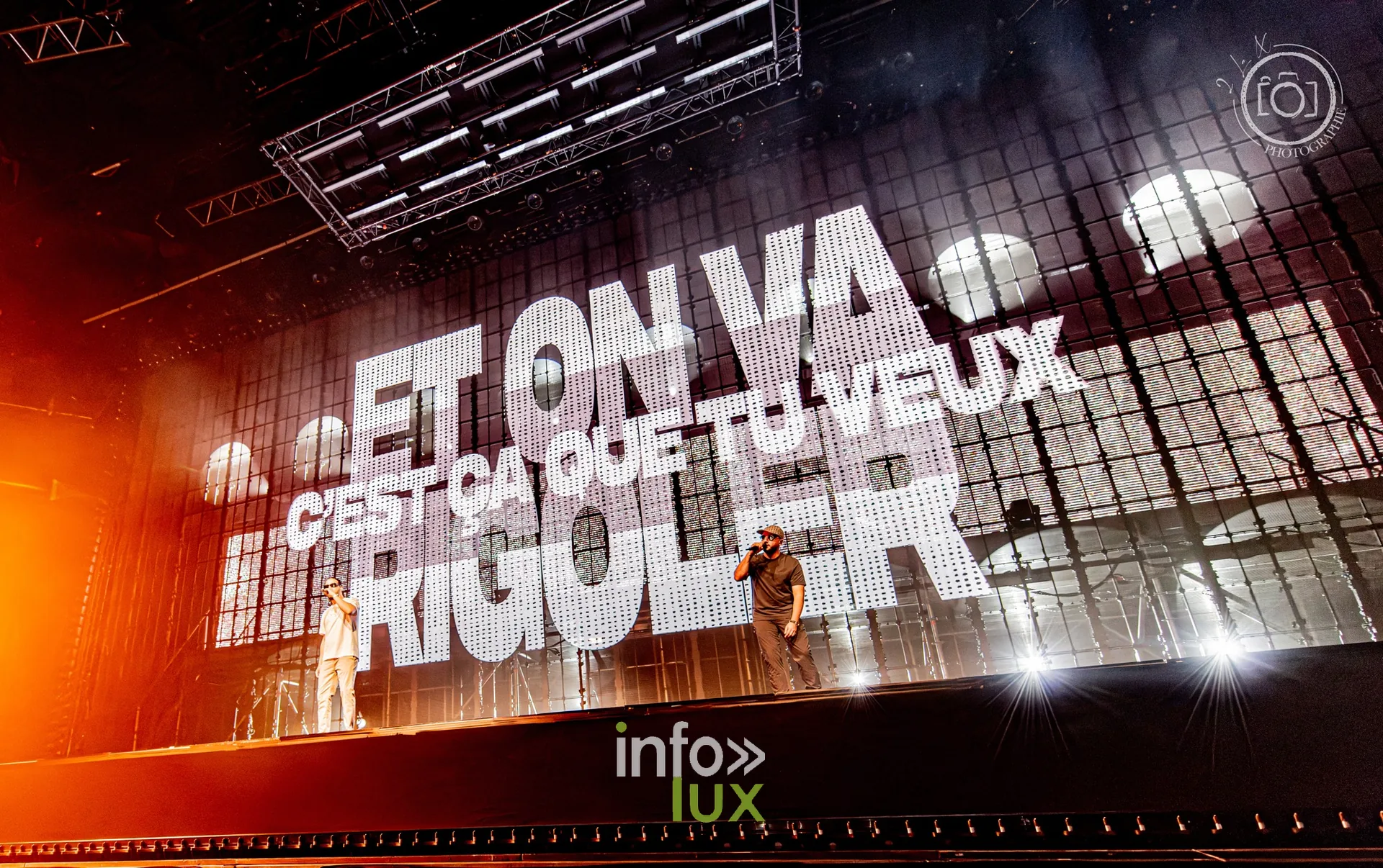 Paroles affichées en lettres géantes sur fond orange, concert de Djadja & Dinaz au Galaxie d’Amnéville, 26 septembre 2026