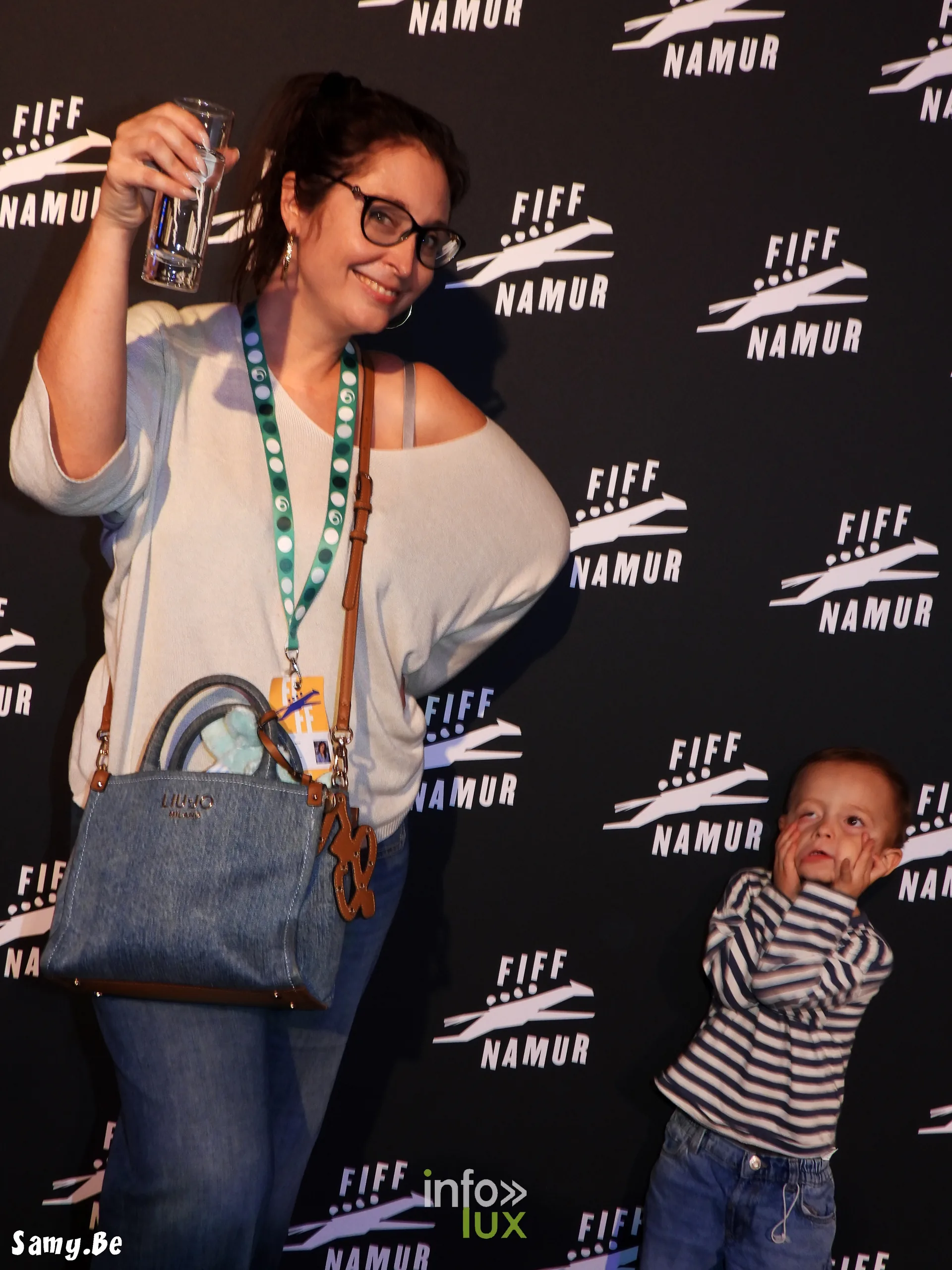 Audrey Devos lève son verre au photocall du FiFF Namur 2026, avec son fils