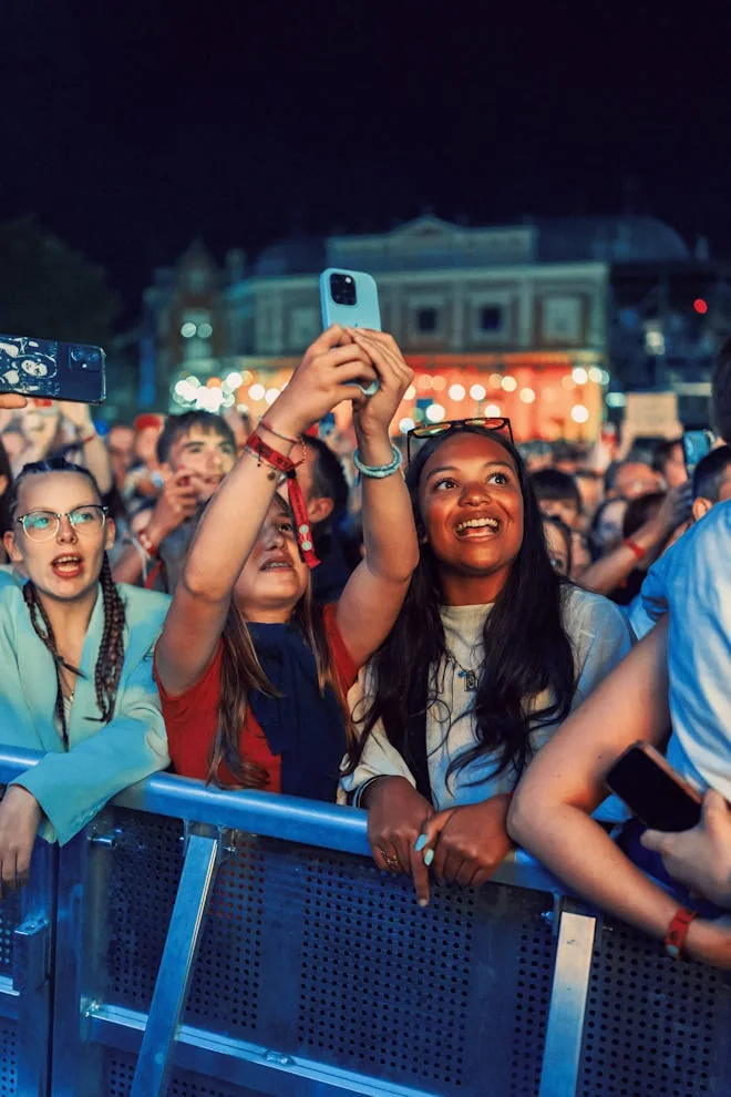 Festivalières au premier rang des Francofolies de Spa 2026, téléphone levé, devant la place Royale