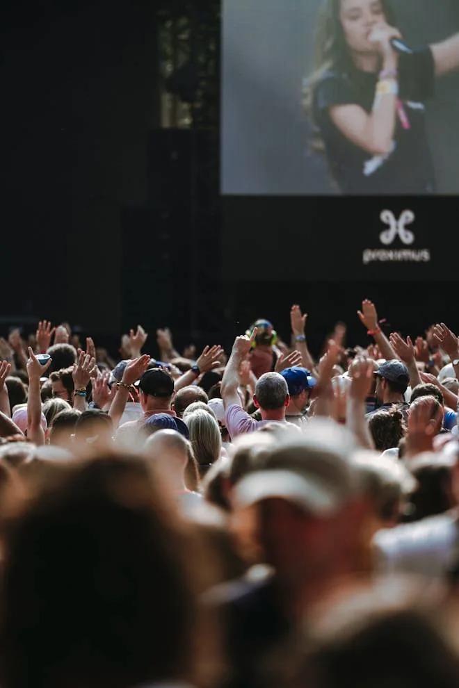 Public des Francofolies de Spa, bras levés devant l’écran géant de la grande scène