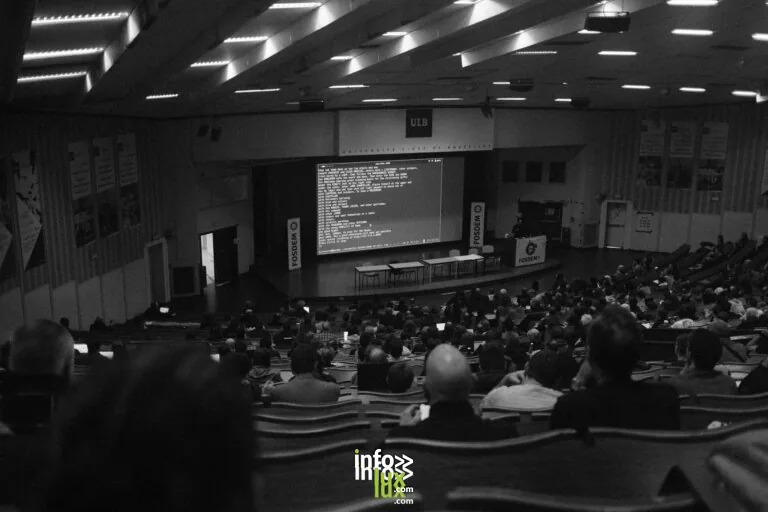 Photographie en noir et blanc d'une conférence technologique à l'auditorium de l'ULB, à Bruxelles.