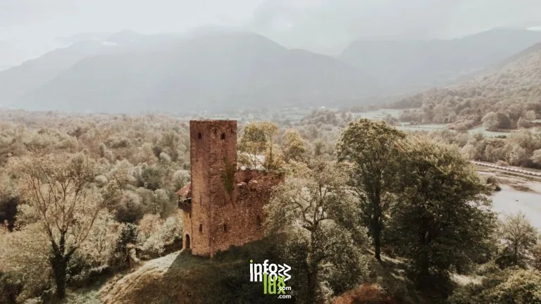 Une tour ancienne pittoresque entourée de verdure luxuriante et de montagnes en Nouvelle-Aquitaine, France.