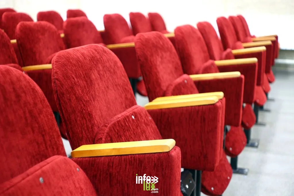Rangs vides d'un auditorium avec des sièges de théâtre en velours rouge plush. Parfait pour des thèmes de cinéma et de s