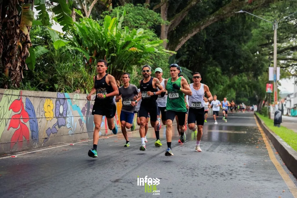 Des athlètes participent à une course sur route animée à Risaralda, en Colombie, entourés d'une végétation luxuriante.