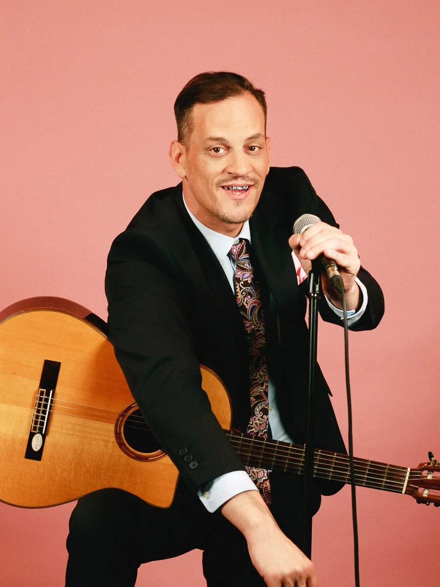 James Deano avec sa guitare, photo de presse de Rire en Gaume 2026