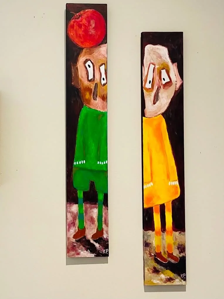 Deux panneaux verticaux de Kathy Philippe accrochés au mur, personnages aux grands yeux