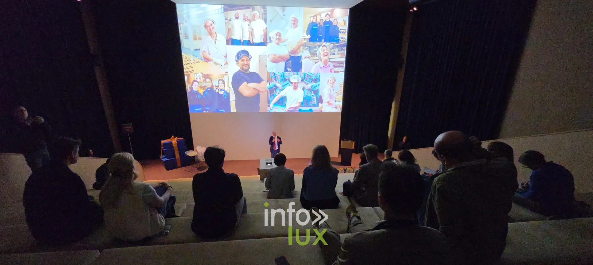 Les invités devant une projection, dans une salle en gradins, inauguration du nouveau site Leonidas à Nivelles, 15 octobre 2026 (photo Karolyn Delisé-Hanse)