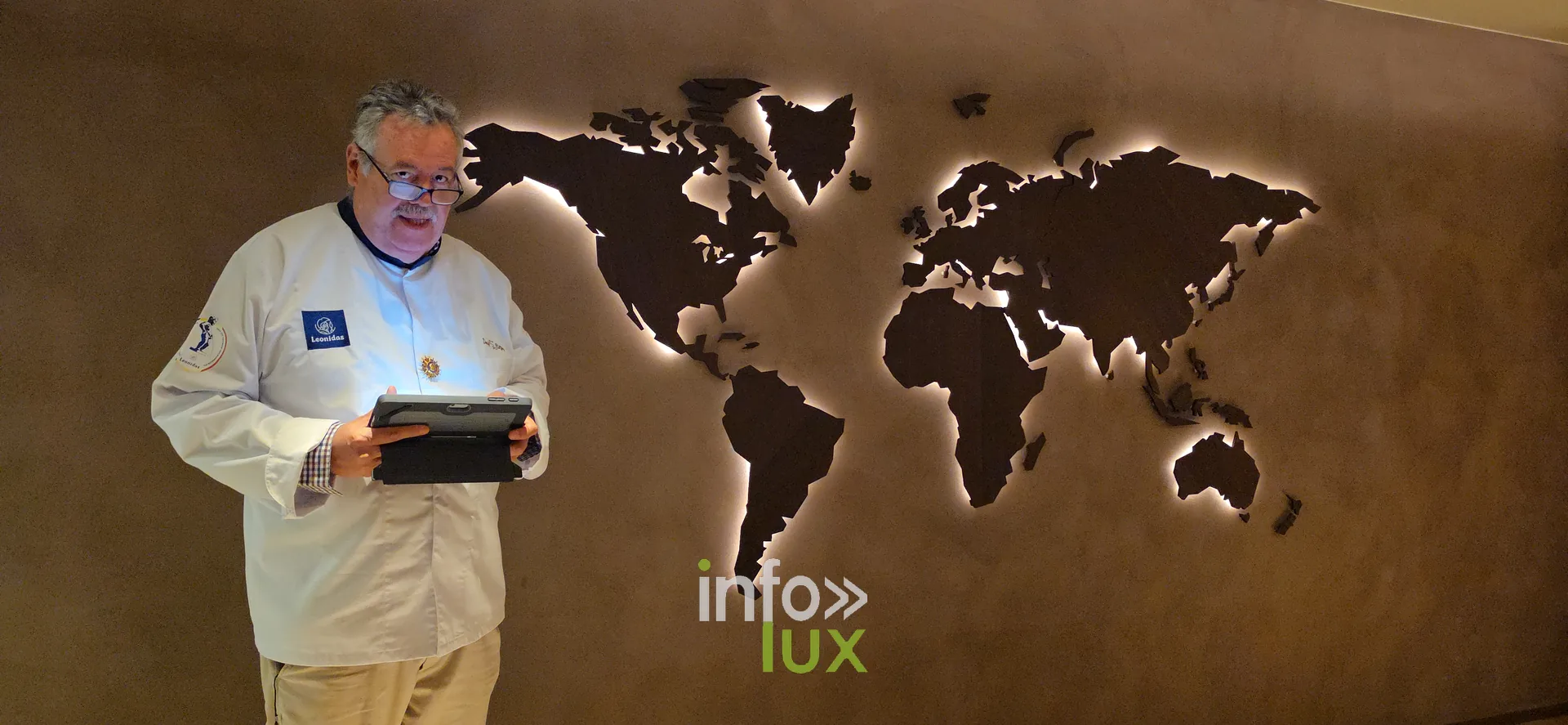 Une carte du monde lumineuse, présentée par un membre de l’équipe en veste de chef, inauguration du nouveau site Leonidas à Nivelles, 15 octobre 2026 (photo Karolyn Delisé-Hanse)