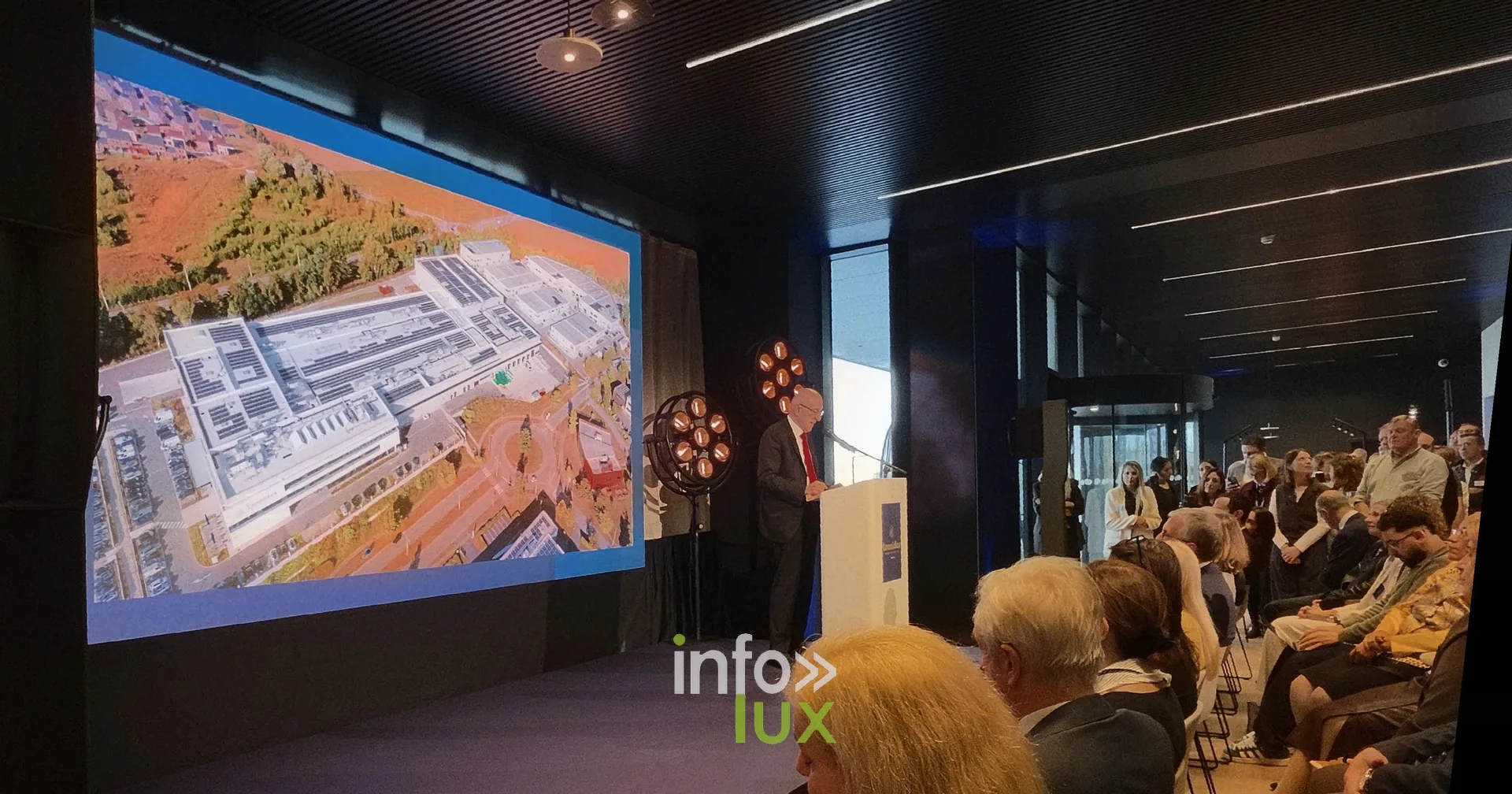 Une vue aérienne projetée pendant les discours, inauguration du nouveau site Leonidas à Nivelles, 15 octobre 2026 (photo Karolyn Delisé-Hanse) — photo modifiée par ia