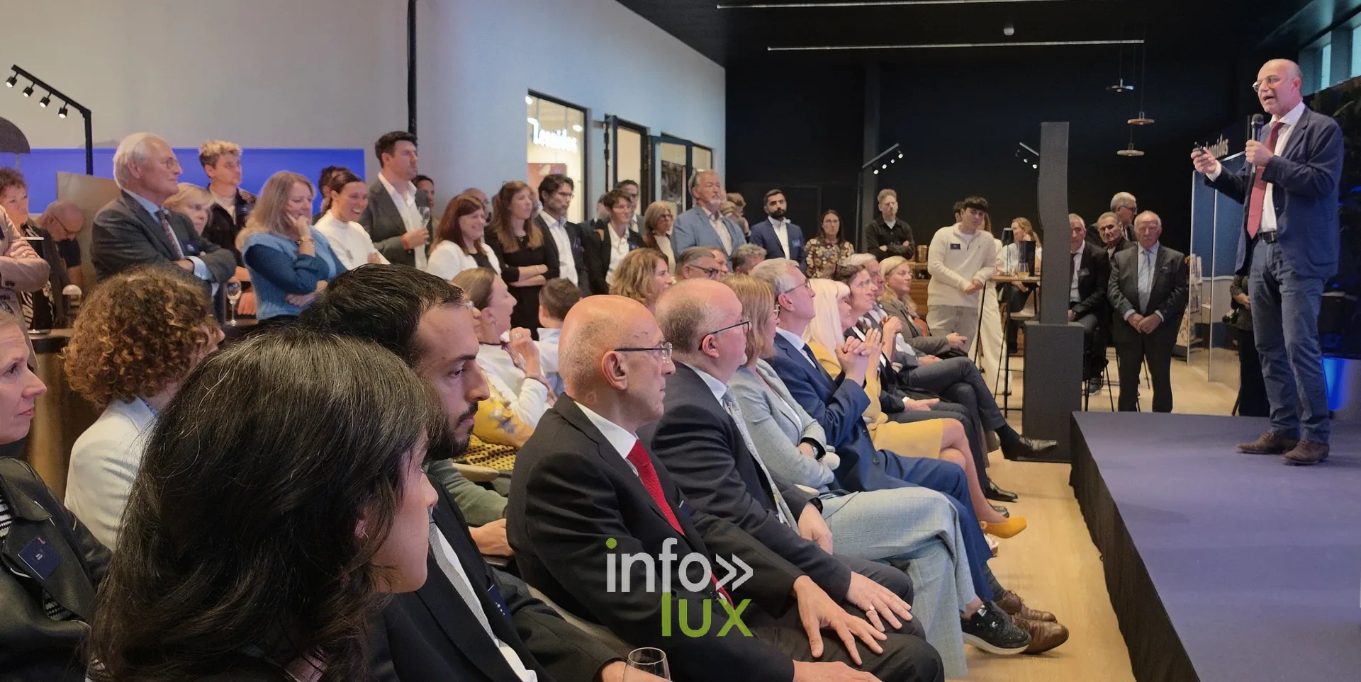 Un discours sur la scène, face aux invités, inauguration du nouveau site Leonidas à Nivelles, 15 octobre 2026 (photo Karolyn Delisé-Hanse) — photo modifiée par ia