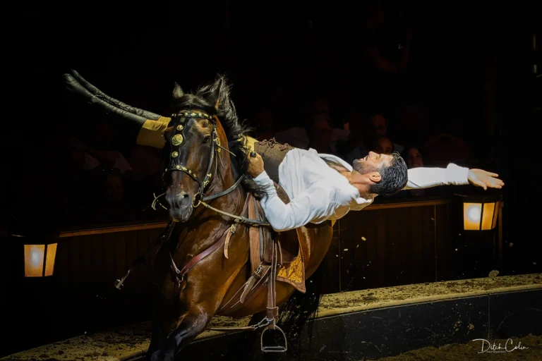 Numéro équestre des Folies Gruss, un artiste renversé sur le dos d’un cheval au galop