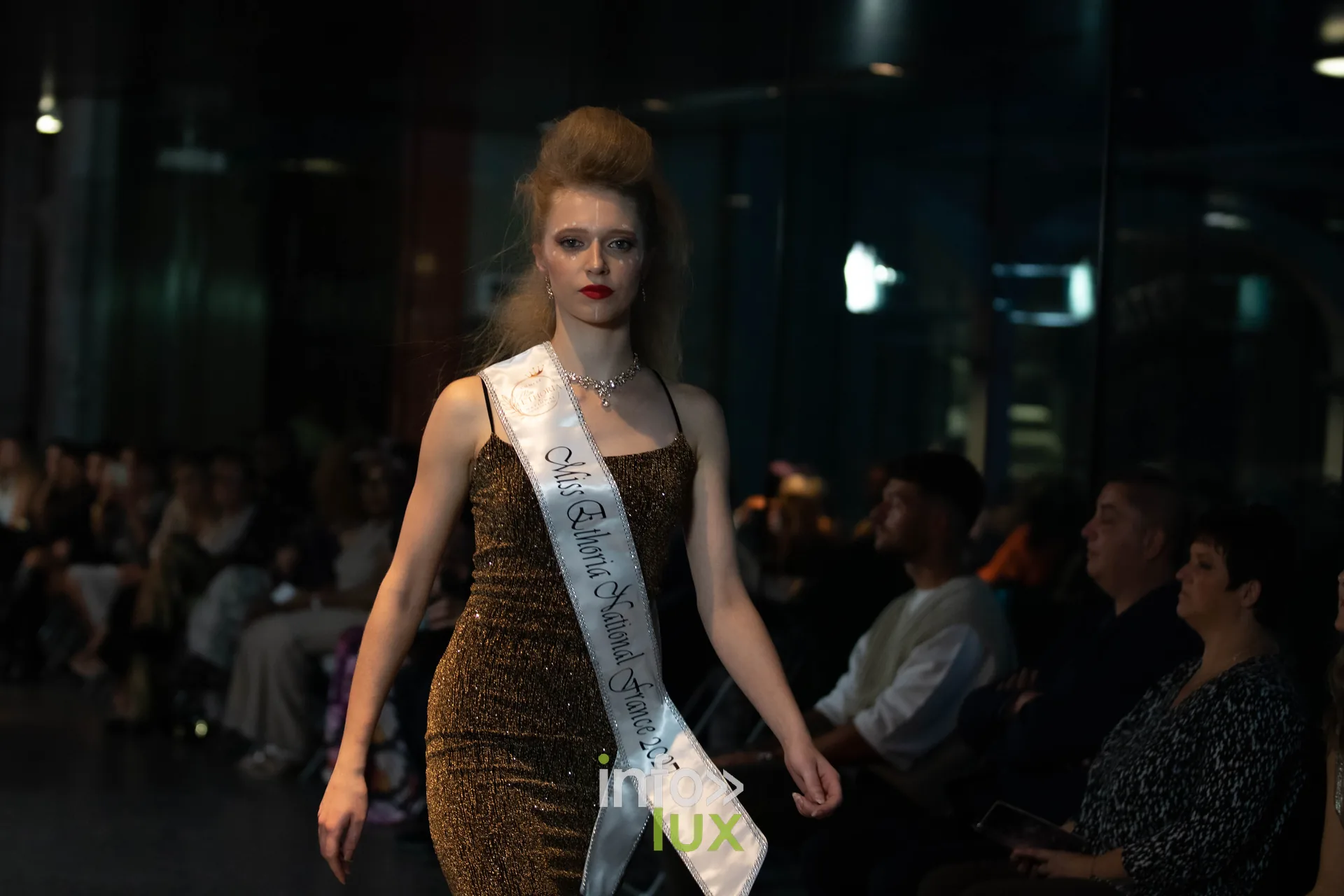 Liège Fashion Week 2026 au Musée Grand Curtius à Liège : mannequin en robe pailletée dorée portant l’écharpe Miss Ethoria National France 2027