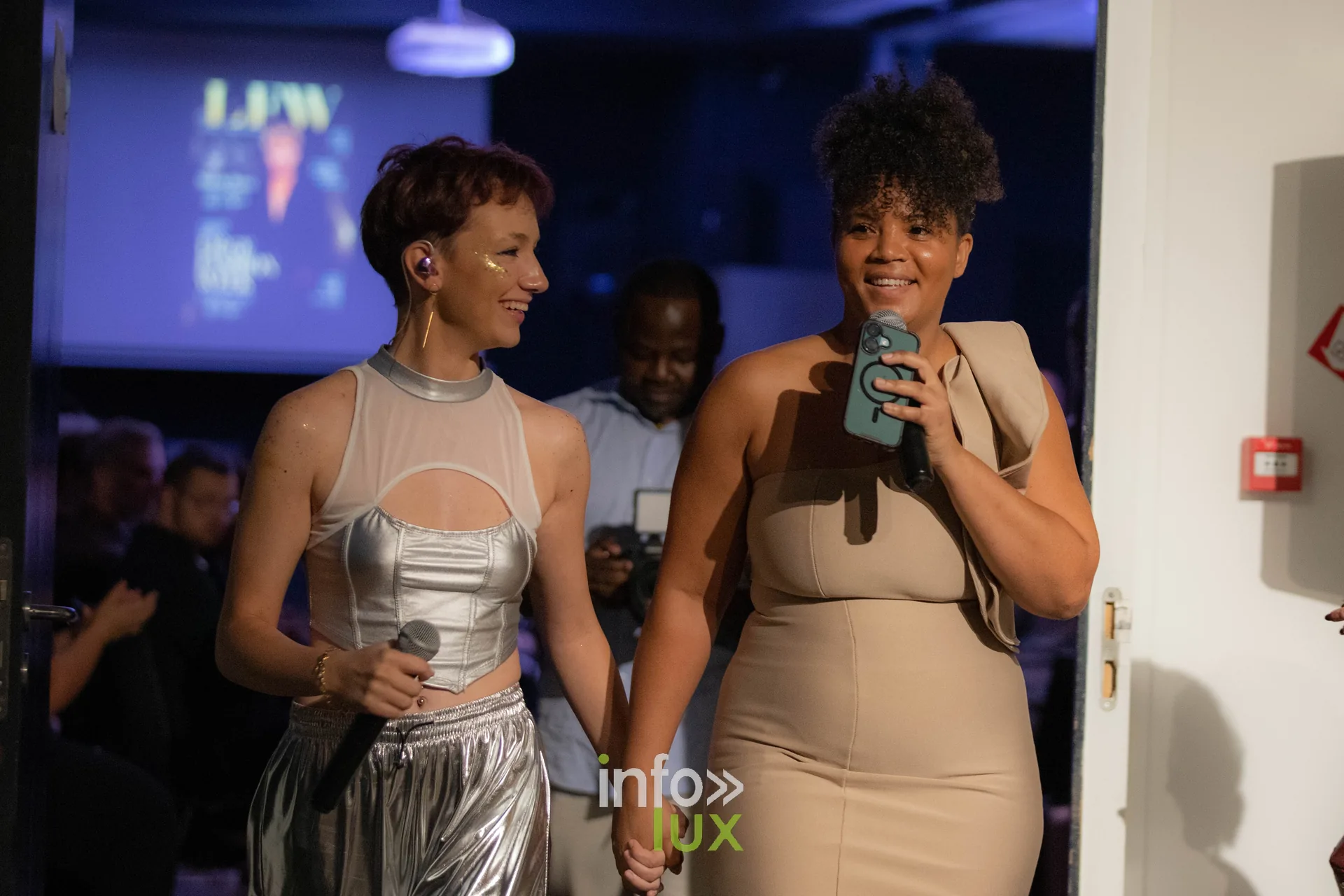 Liège Fashion Week 2026 au Musée Grand Curtius à Liège : chanteuse en tenue argentée et présentatrice au micro sur scène