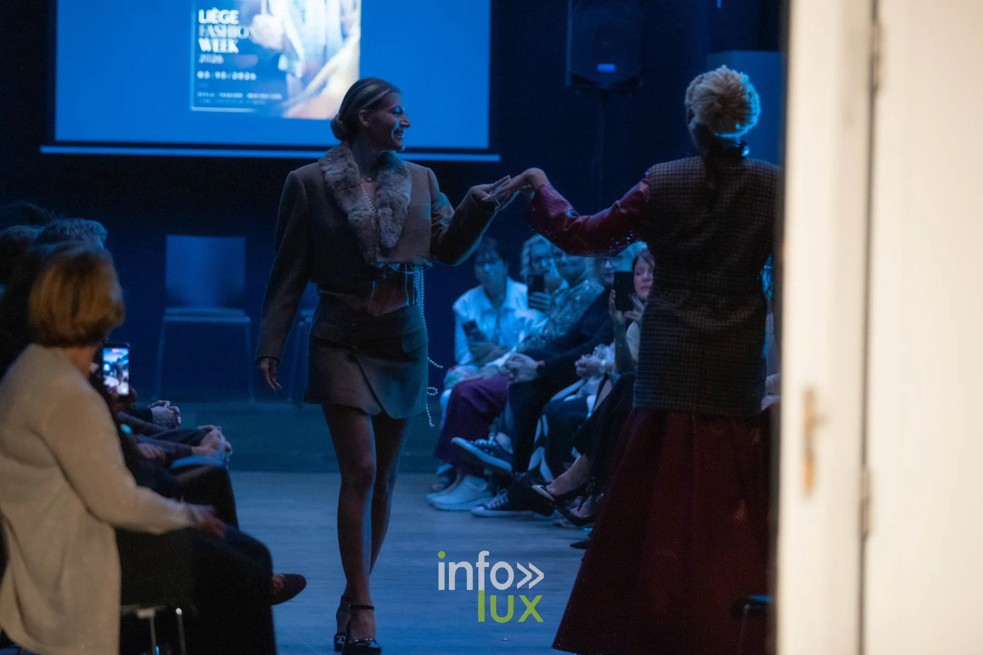 Liège Fashion Week 2026 au Musée Grand Curtius à Liège : passage de mannequins sous lumière bleue devant l’écran de la Liège Fashion Week