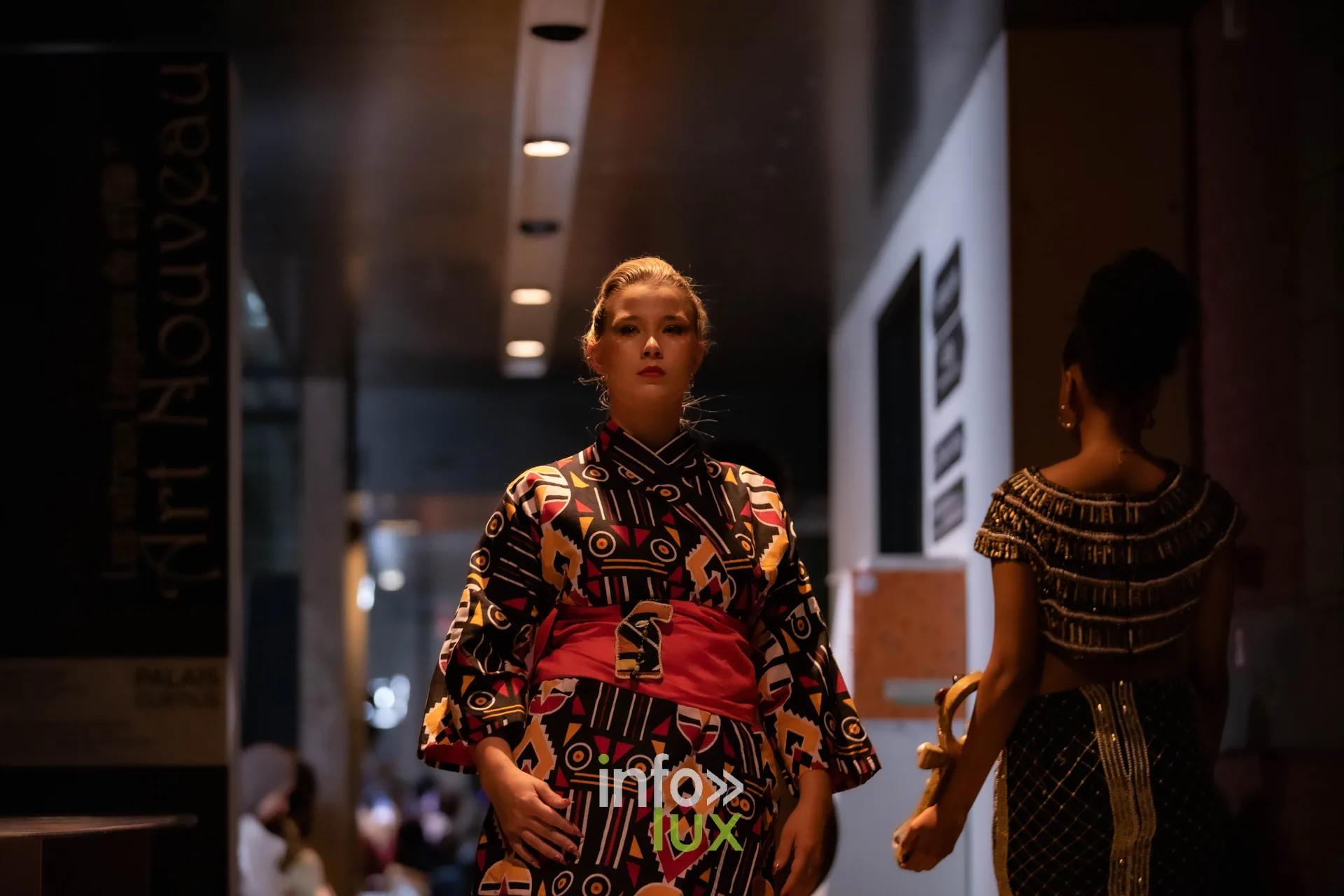 Liège Fashion Week 2026 au Musée Grand Curtius à Liège : mannequin en kimono de wax rouge et noir à ceinture rouge