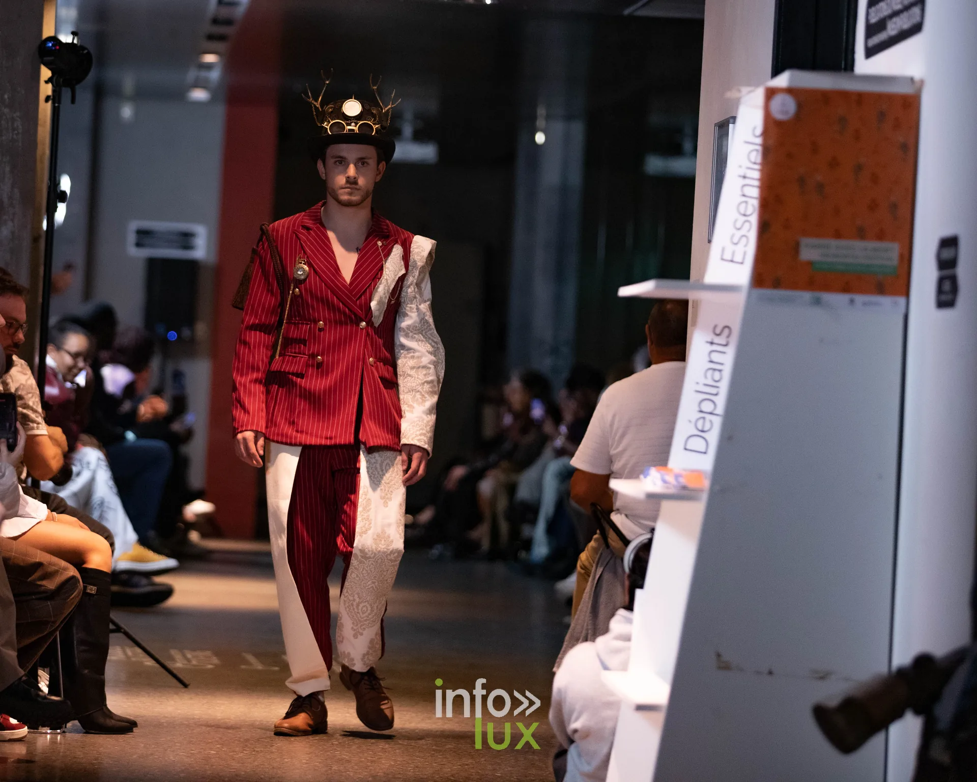 Liège Fashion Week 2026 au Musée Grand Curtius à Liège : mannequin en costume rouge rayé et pantalon blanc, couronne dorée