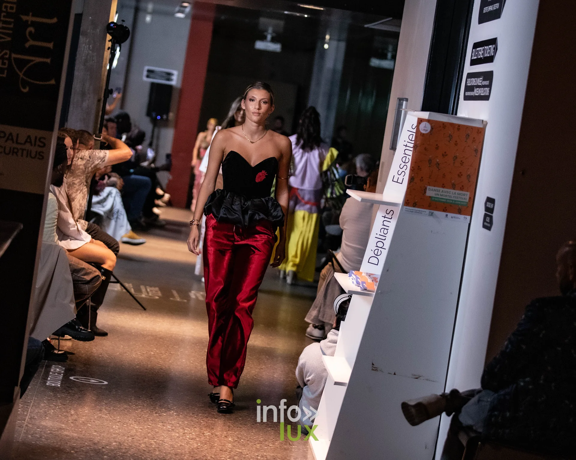 Liège Fashion Week 2026 au Musée Grand Curtius à Liège : mannequin en bustier noir et pantalon de satin rouge