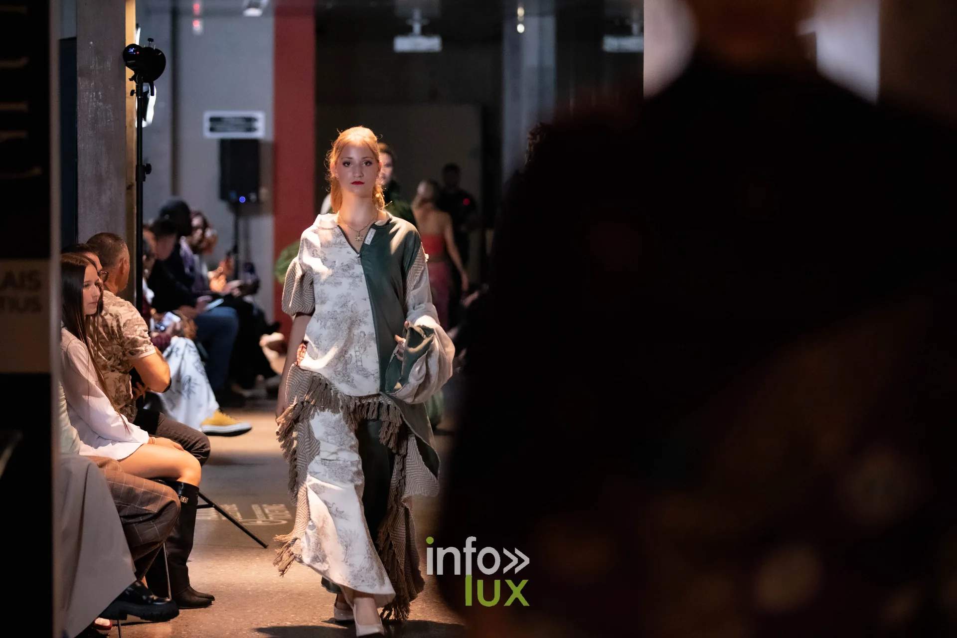 Liège Fashion Week 2026 au Musée Grand Curtius à Liège : mannequin en tenue blanche et verte à franges