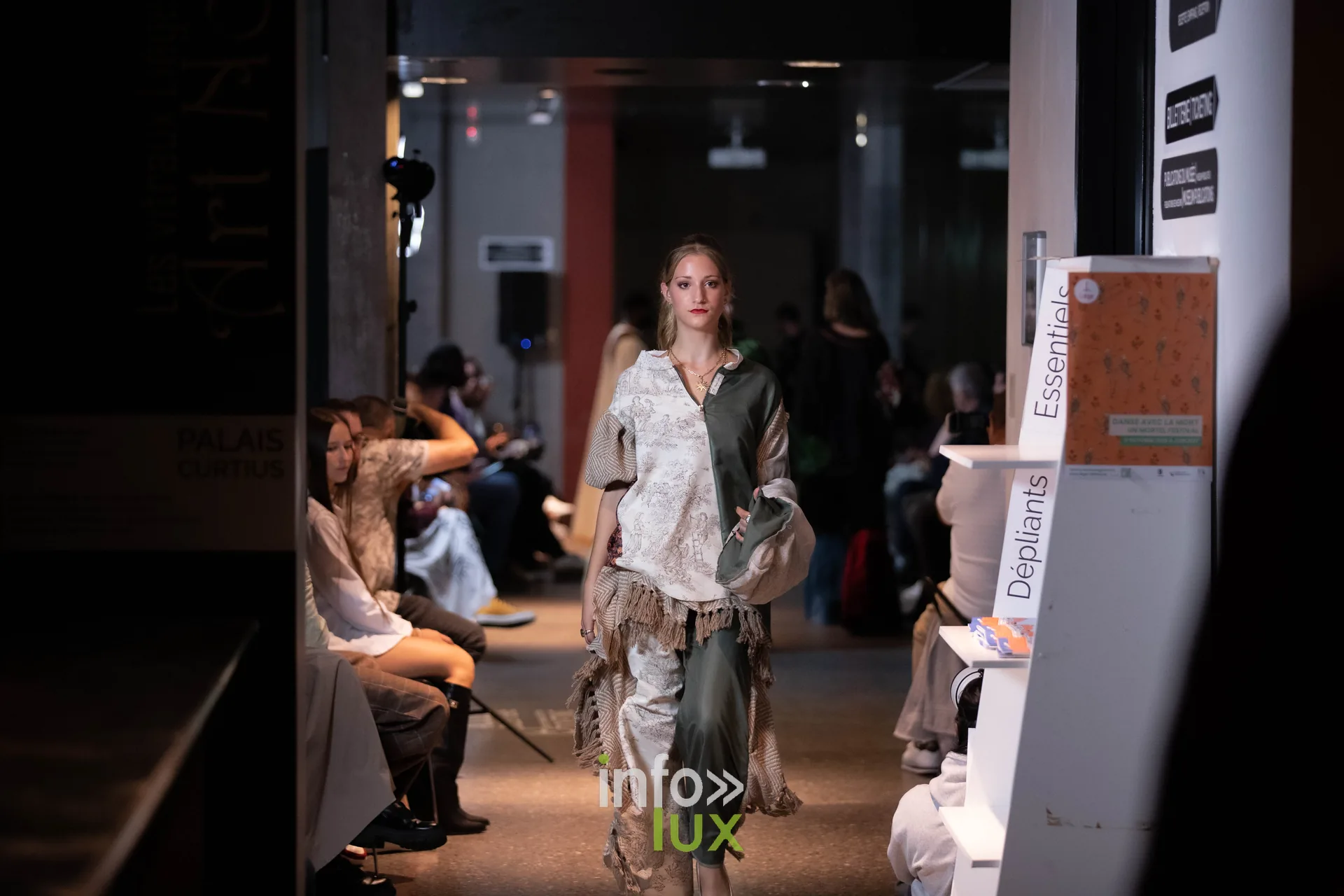 Liège Fashion Week 2026 au Musée Grand Curtius à Liège : mannequin en tenue blanche et verte à franges devant le public
