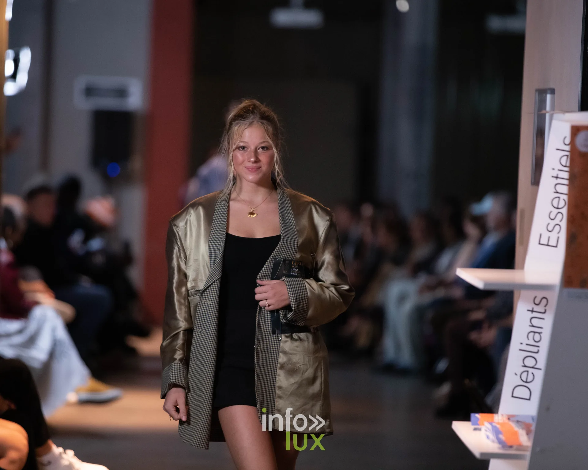 Liège Fashion Week 2026 au Musée Grand Curtius à Liège : mannequin en veste dorée oversize sur robe noire