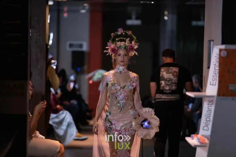 Liège Fashion Week 2026 au Musée Grand Curtius à Liège : mannequin en robe fleurie rose, couronne de fleurs et fleur lumineuse