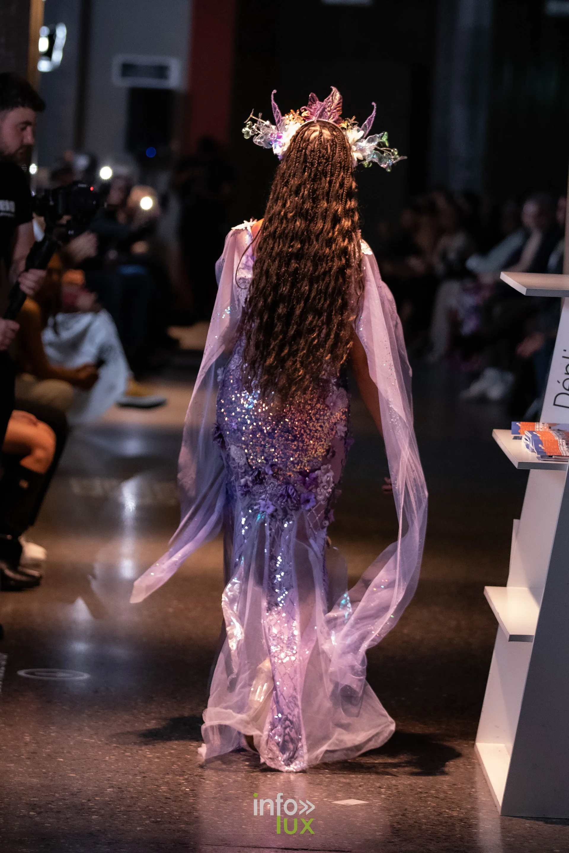 Liège Fashion Week 2026 au Musée Grand Curtius à Liège : mannequin en robe mauve vue de dos, longue chevelure