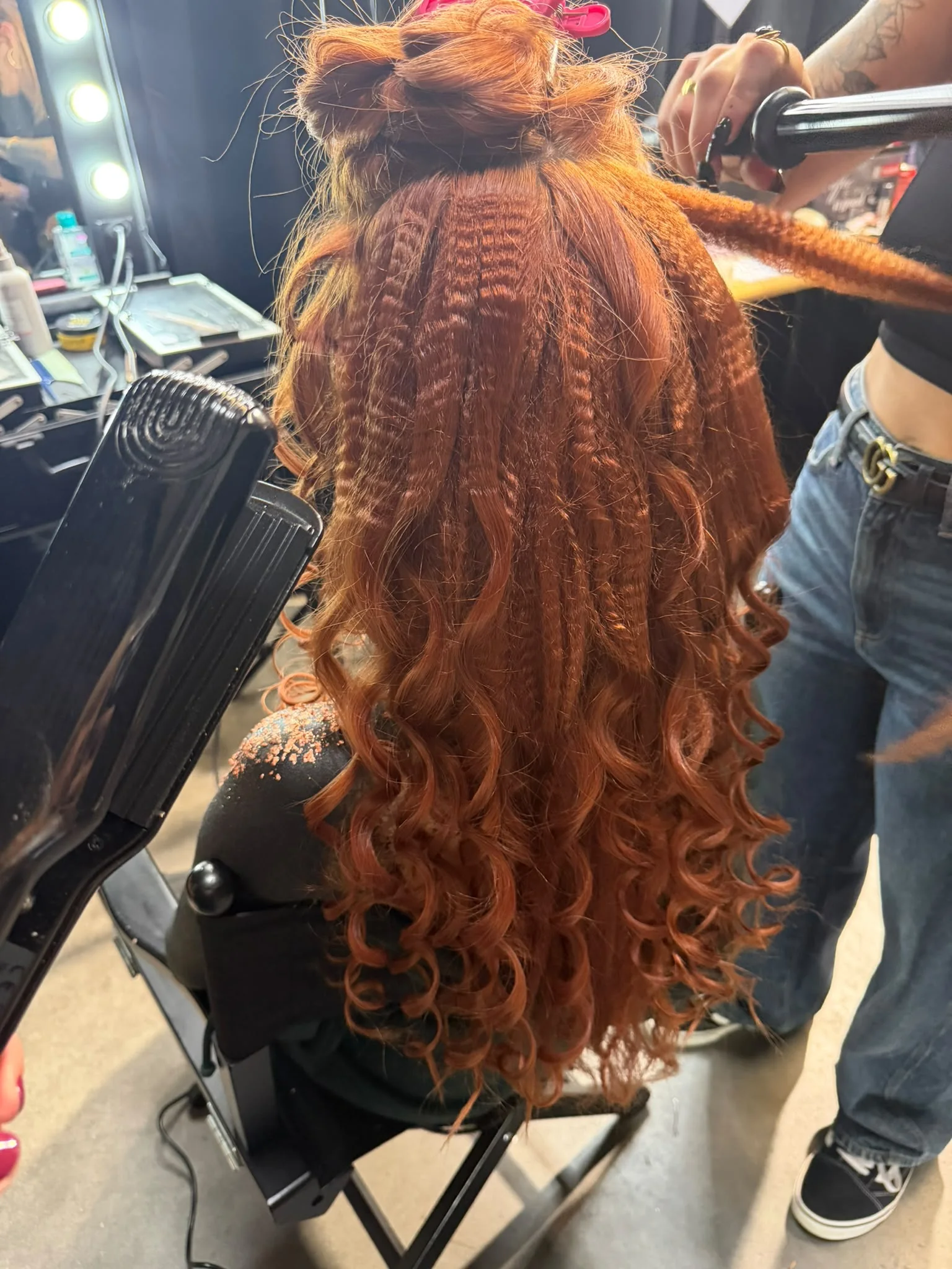 La coiffure de Marine vue de dos : longues mèches rousses crêpées et bouclées